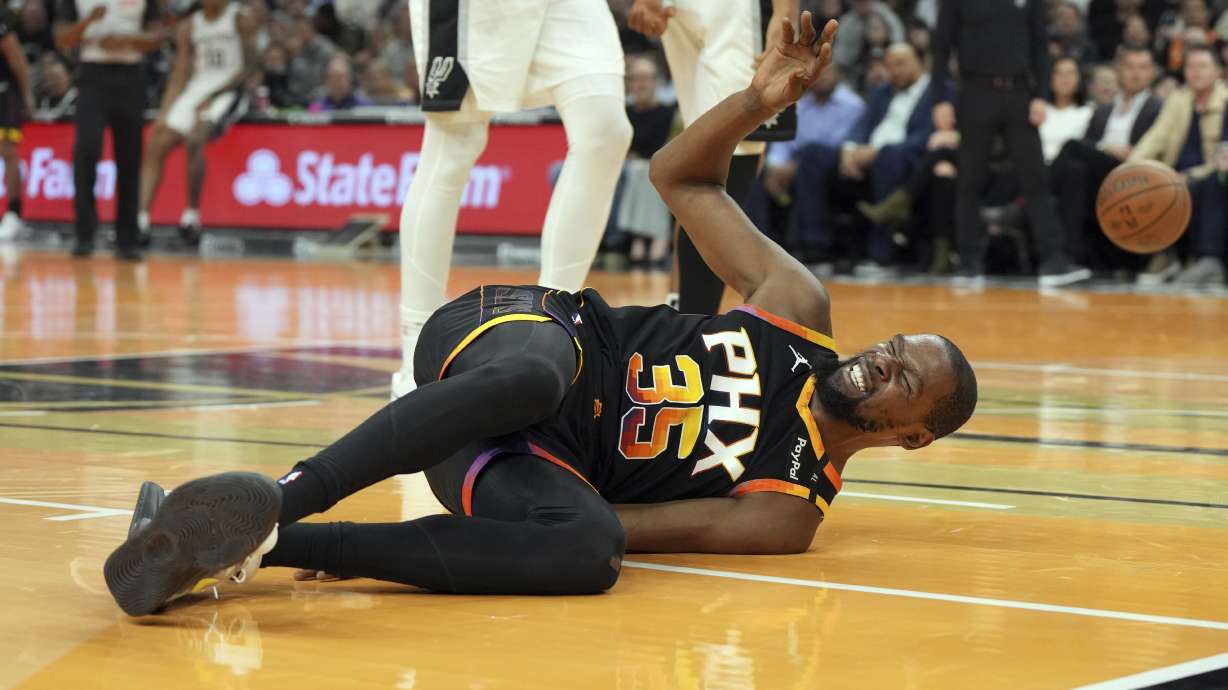 Phoenix Suns forward Kevin Durant reacts after falling to the floor against the San Antonio Spurs during the first half of an NBA basketball game, Tuesday, Dec. 3, 2024, in Phoenix.