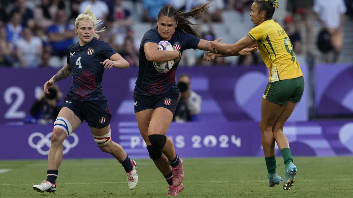 FILE - United States' Ilona Maher, enter gets past the tackle of Brazil's Gabriela Lima, right, during the women's Pool C Rugby Sevens match between the United States and Brazil at the 2024 Summer Olympics, in the Stade de France, in Saint-Denis, France, Sunday, July 28, 2024. , File)