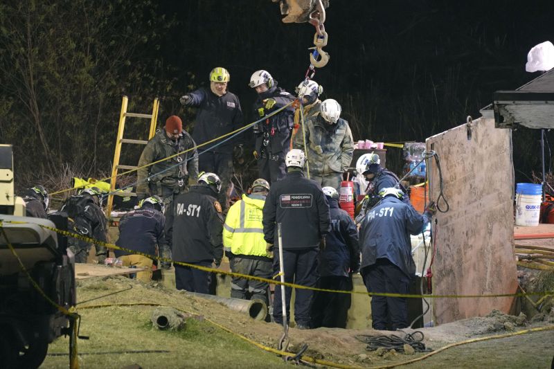 Rescue workers search through the night in a sinkhole for Elizabeth Pollard, who disappeared while looking for her cat, in Marguerite, Pa., Tuesday.