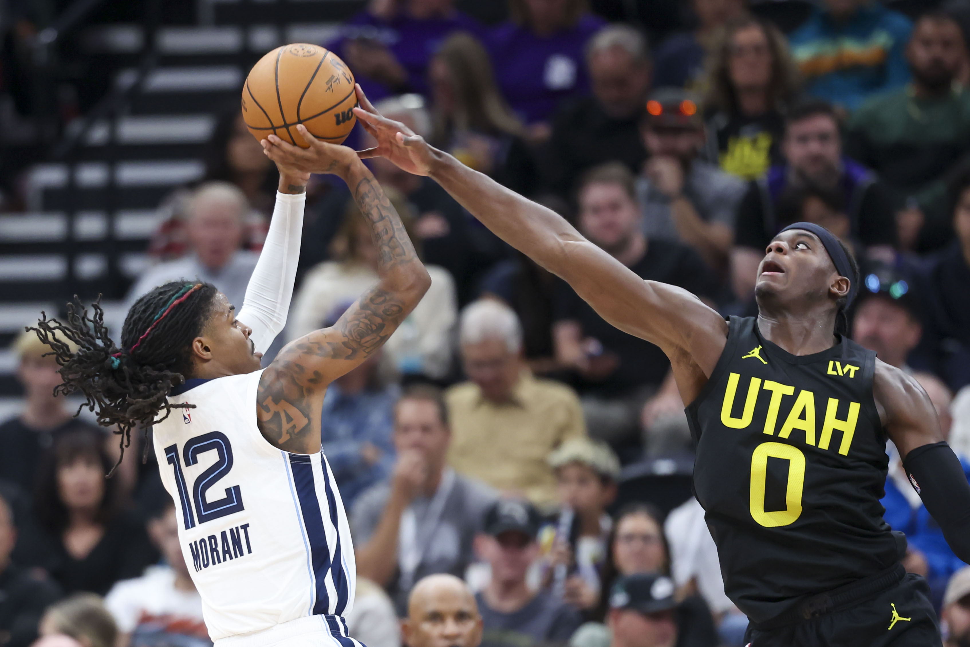 FILE - Utah Jazz forward Taylor Hendricks (0) blocks the shot of Memphis Grizzlies guard Ja Morant (12) during the second half of an NBA basketball game, on Oct. 23, 2024, in Salt Lake City. After suffering a gruesome season-ending leg injury, Utah Jazz forward Taylor Henricks is taking an optimistic approach to a lengthy rehab and finding ways to stay involved with the team this season.