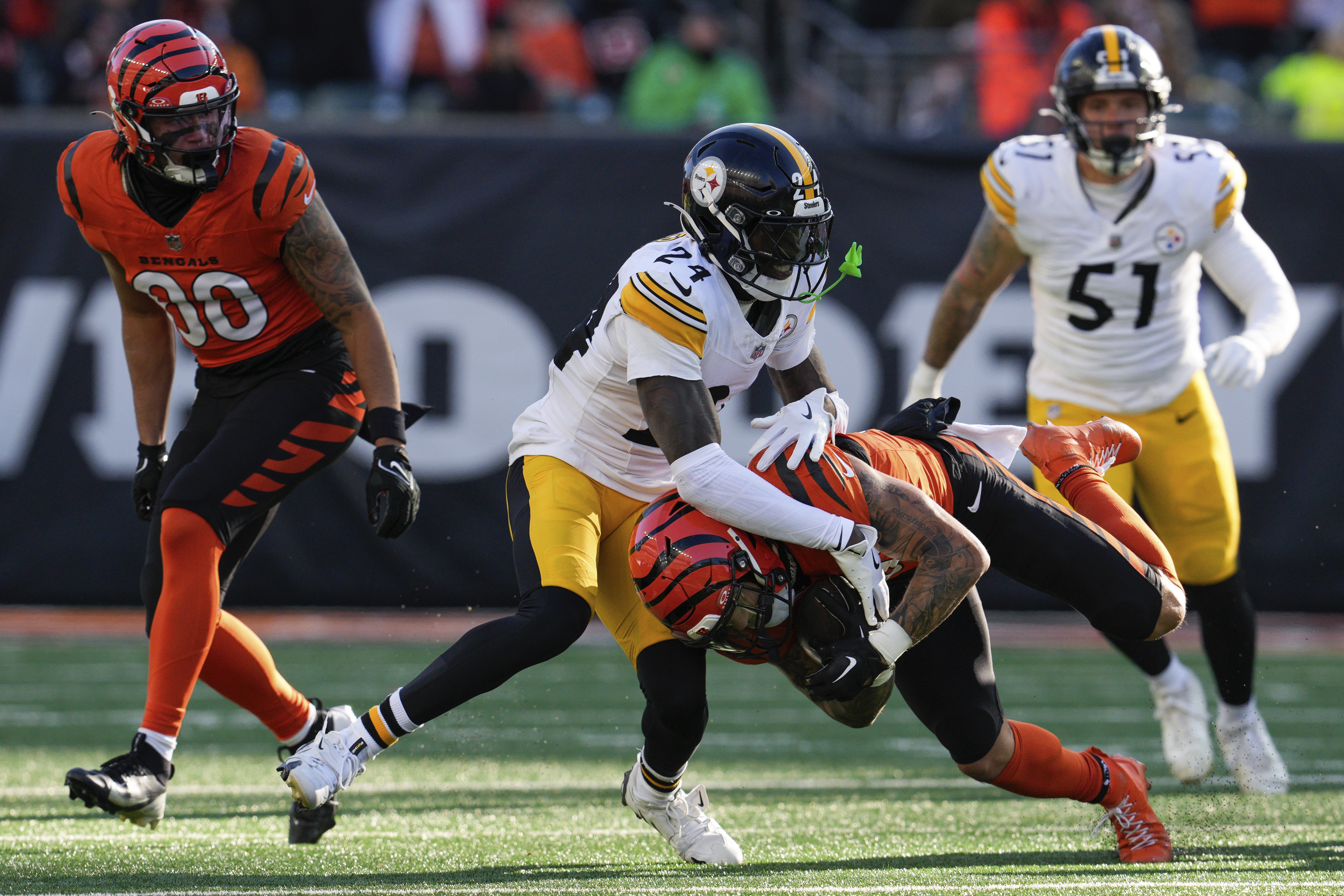 Pittsburgh Steelers cornerback Joey Porter Jr. (24) tackles Cincinnati Bengals running back Chase Brown, center bottom, during the first half of an NFL football game Sunday, Dec. 1, 2024, in Cincinnati.