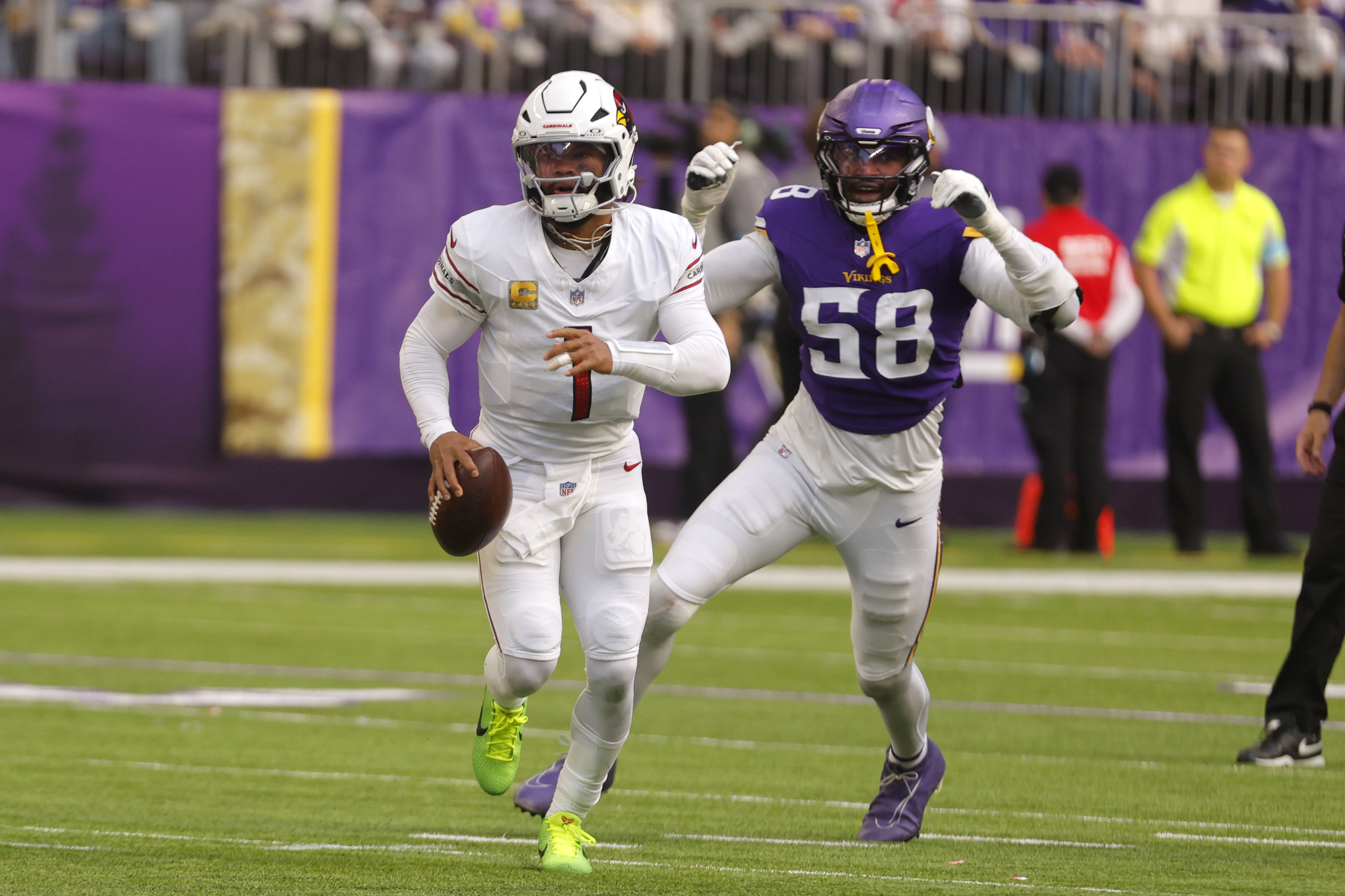 Arizona Cardinals quarterback Kyler Murray (1) runs from Minnesota Vikings linebacker Jonathan Greenard (58) during the first half of an NFL football game Sunday, Dec. 1, 2024, in Minneapolis.