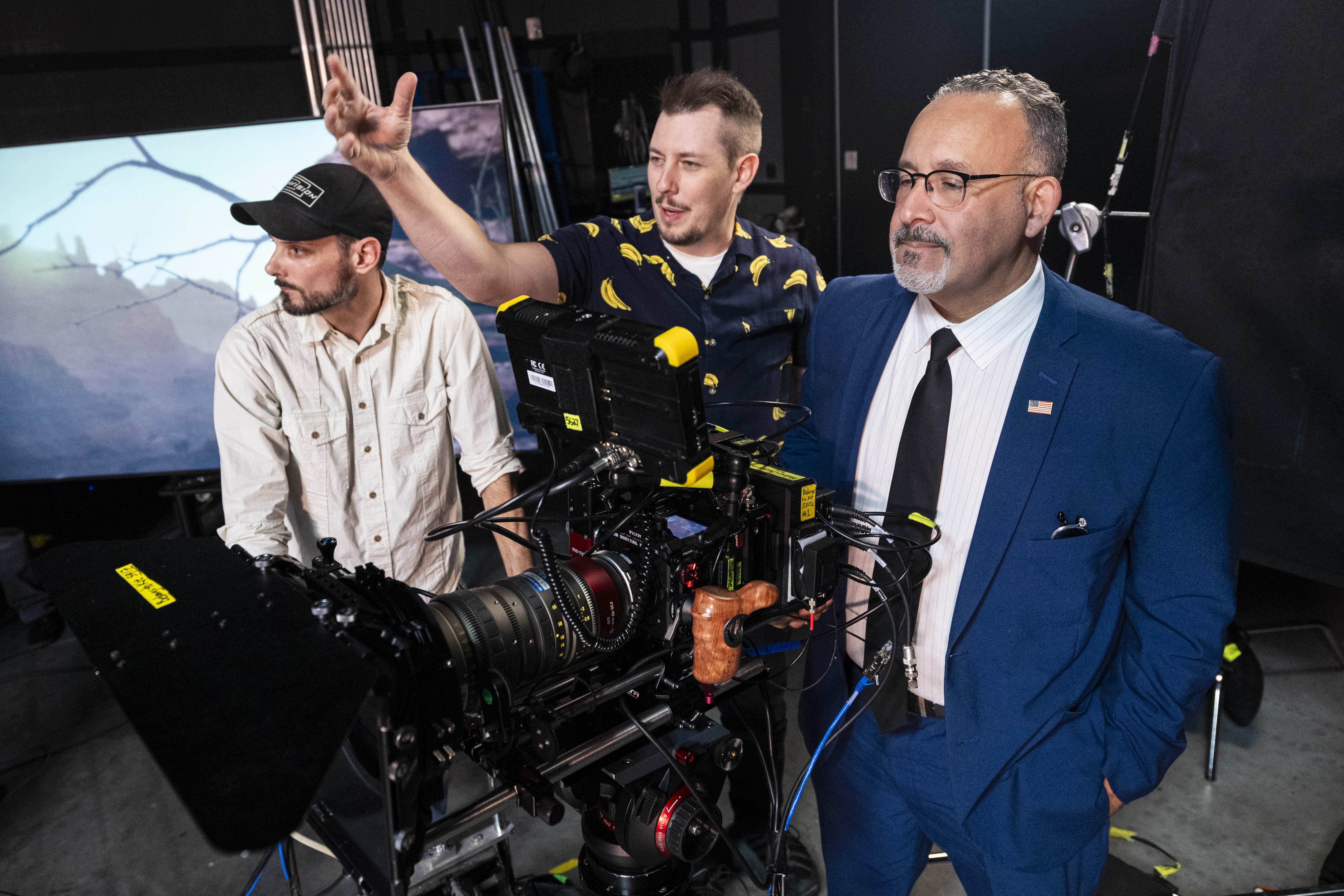 U.S. Secretary of Education Miguel Cardona, right, mans a camera beside Jake Dickey, center, an adjunct professor and director of in-camera visual effects, and Dave Lehleitner, an associate professor of film, in a photo and video production studio at the South City Campus of Salt Lake Community College in Salt Lake City during Cardona’s visit on Wednesday.