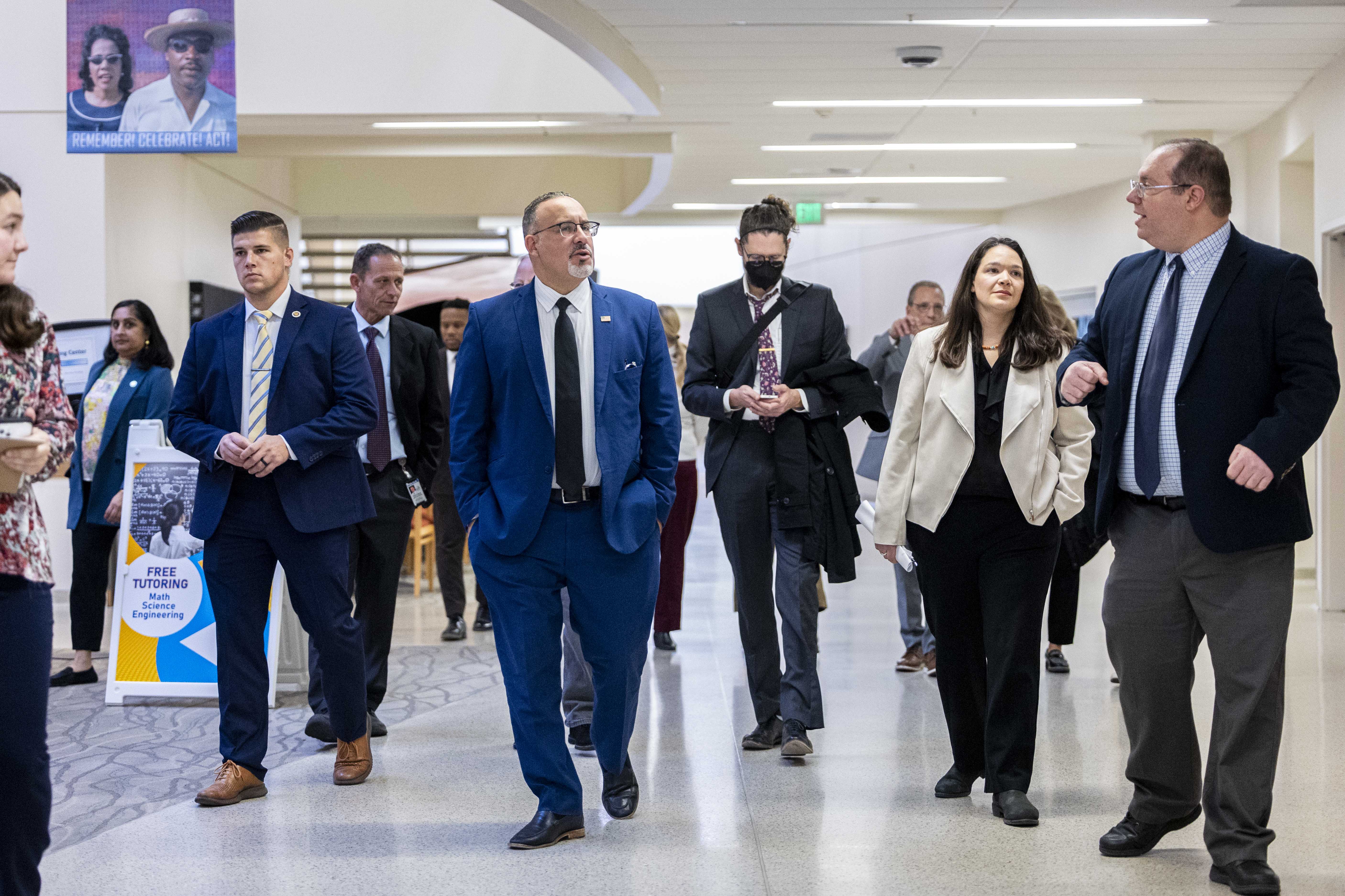 U.S. Secretary of Education Miguel Cardona, center left, talks to Josh Elstein, right, program director for arts and new media, as Cardona tours the South City Campus of Salt Lake Community College in Salt Lake City during a visit Wednesday.