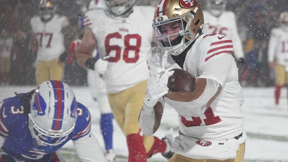San Francisco 49ers running back Isaac Guerendo, right, runs for a touchdown past Buffalo Bills safety Damar Hamlin (3) during the second half of an NFL football game in Orchard Park, N.Y., Sunday, Dec. 1, 2024.