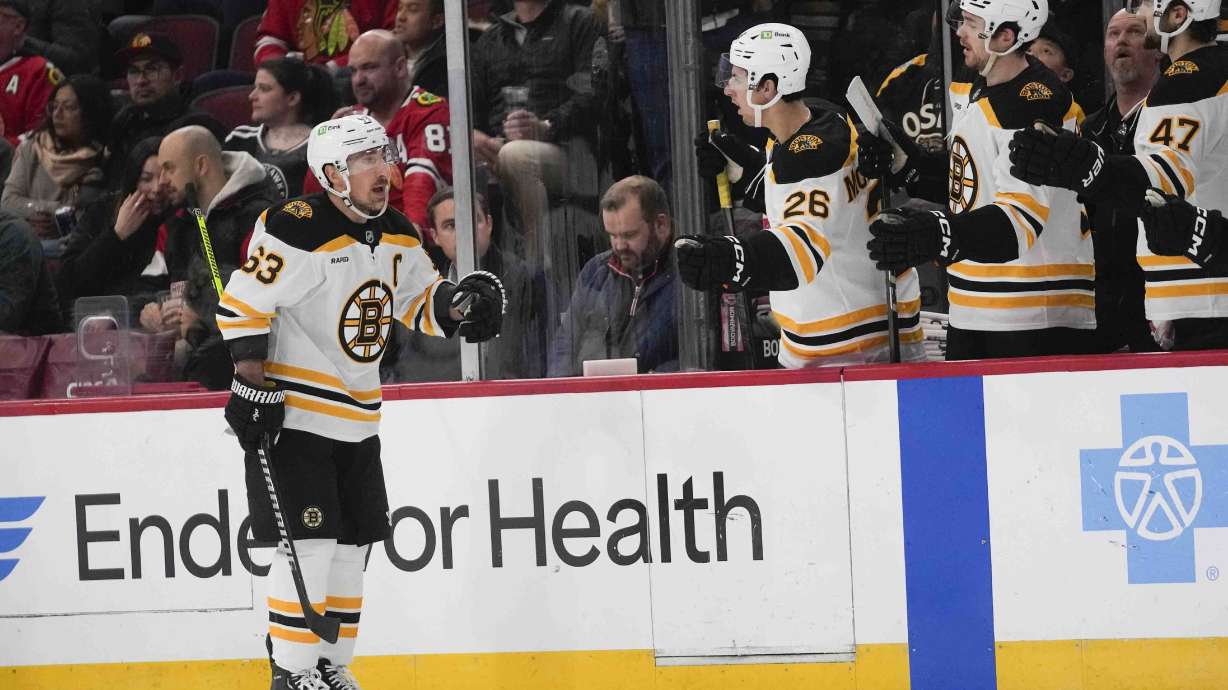 Boston Bruins left wing Brad Marchand, left, celebrates after scoring on the Chicago Blackhawks during the second period of an NHL hockey game Wednesday, Dec. 4, 2024, in Chicago.