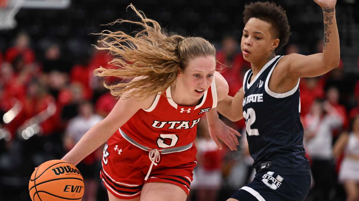 Utah Utes guard Gianna Kneepkens (5) drives on Utah State Aggies guard Taliyah Logwood (22) as Utah and Utah State women play at the Delta Center in Salt Lake City on Wednesday Dec. 4, 2024.