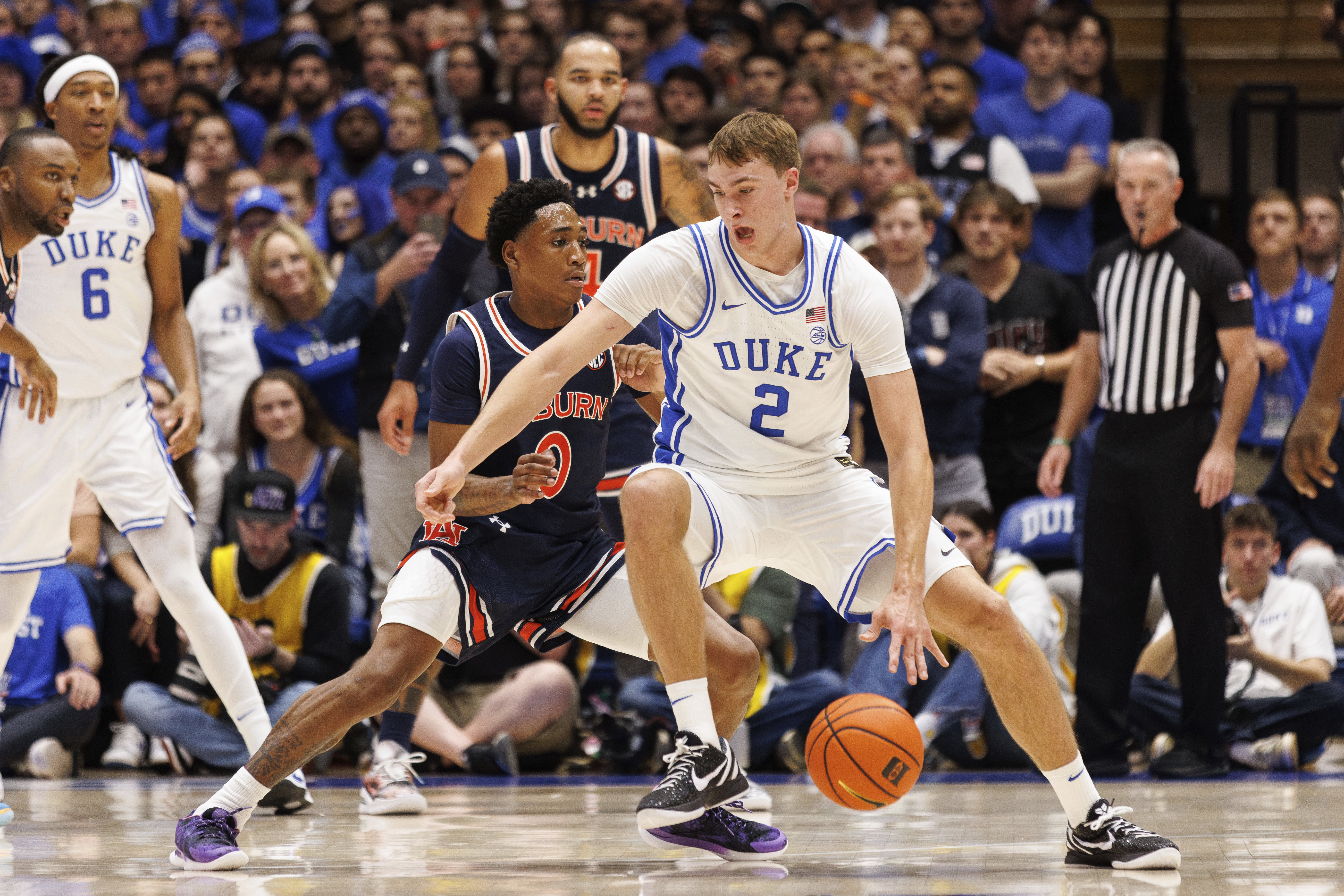 Duke's Cooper Flagg (2) handles the ball as Auburn's Tahaad Pettiford (0) defends during the first half of an NCAA college basketball game in Durham, N.C., Wednesday, Dec. 4, 2024.