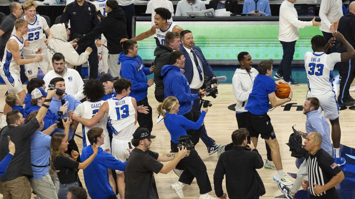 Creighton fans rush the court to celebrate with players following their 76-63 win against Kansas in an NCAA college basketball game Wednesday, Dec. 4, 2024, in Omaha, Neb.