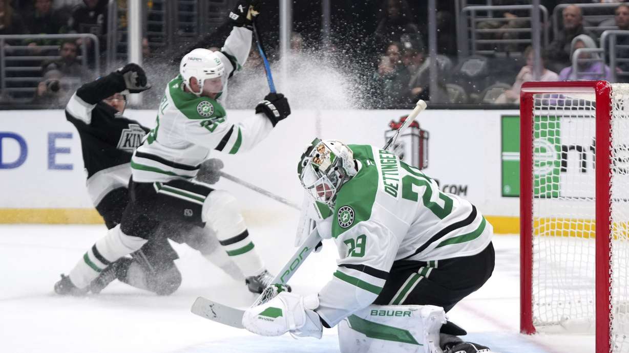 Dallas Stars goaltender Jake Oettinger, right, stops a shot as Los Angeles Kings defenseman Jordan Spence, left, and defenseman Esa Lindell tangle during the second period of an NHL hockey game, Wednesday, Dec. 4, 2024, in Los Angeles.