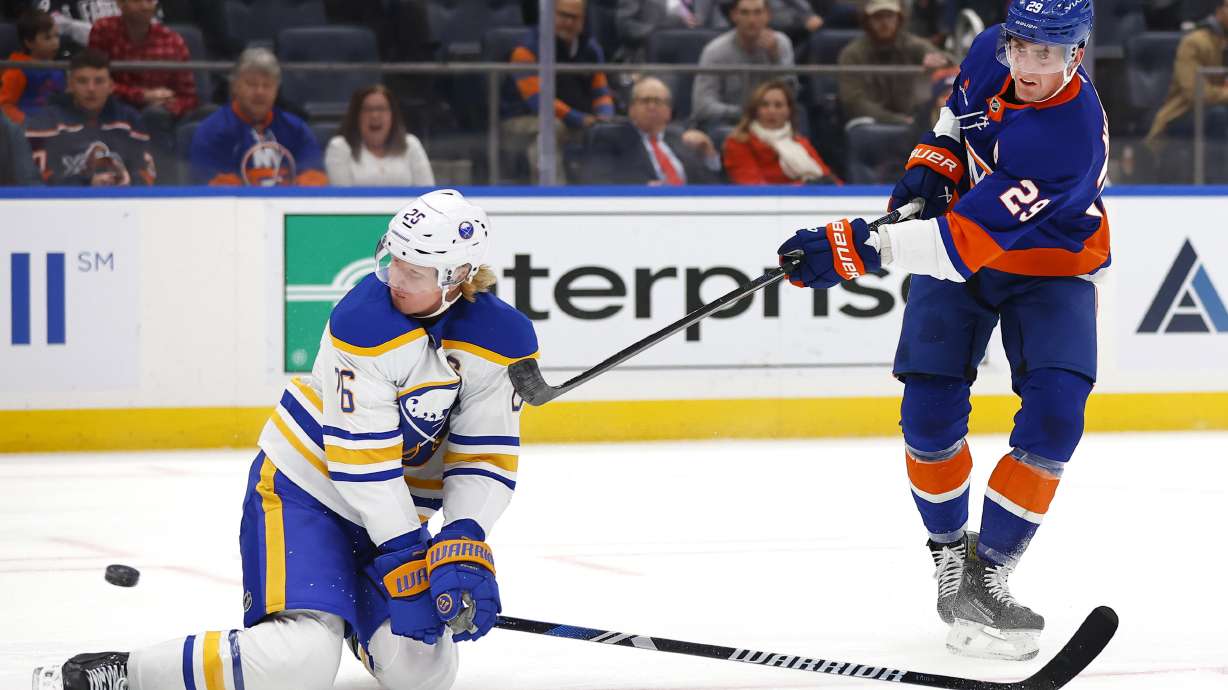 New York Islanders center Brock Nelson (29) shoots the puck against Buffalo Sabres defenseman Rasmus Dahlin (26) during the second period of an NHL hockey game, Saturday, Nov. 30, 2024, in Elmont, N.Y.