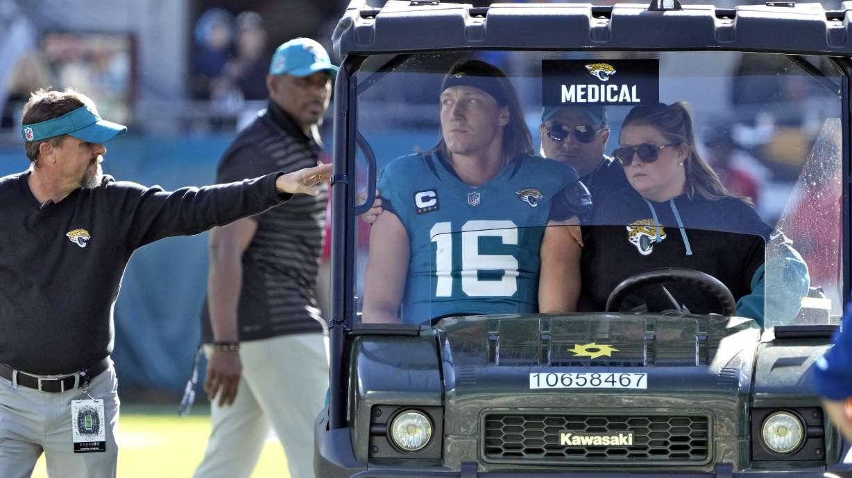 Jacksonville Jaguars quarterback Trevor Lawrence (16) leaves the field on a cart after getting injured on a late hit by Houston Texans linebacker Azeez Al-Shaair during the first half of an NFL football game Sunday, Dec. 1, 2024, in Jacksonville, Fla.