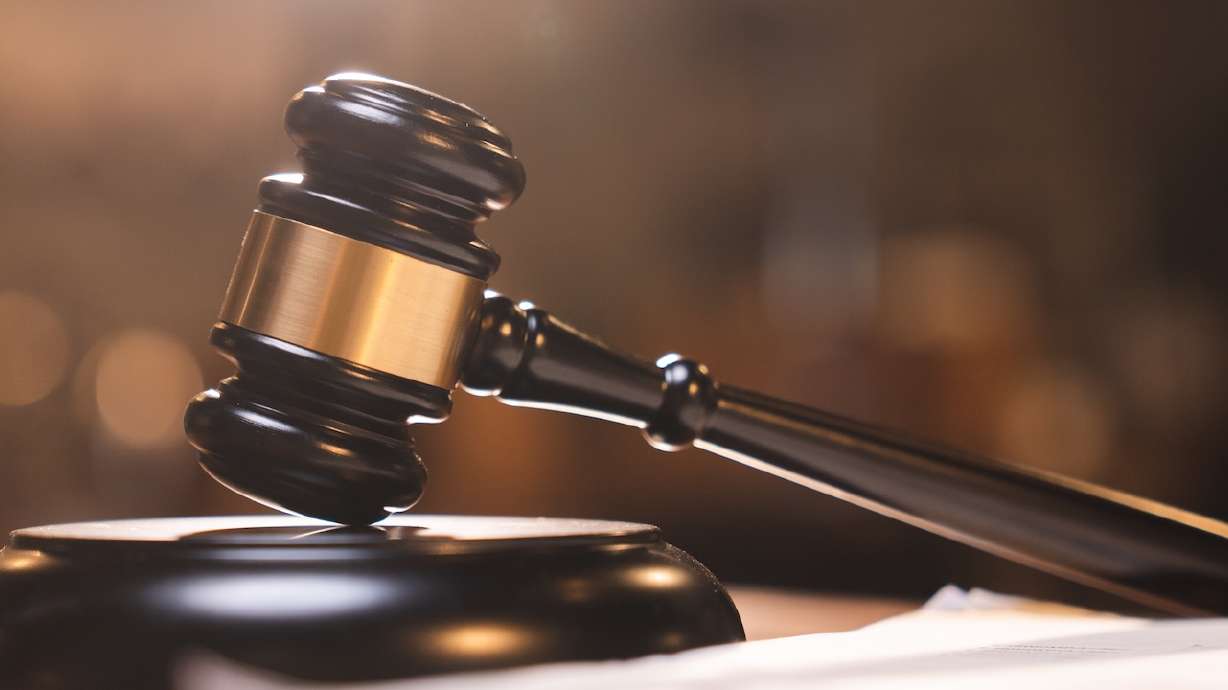 Judge gavel on the table with blurry books in the background