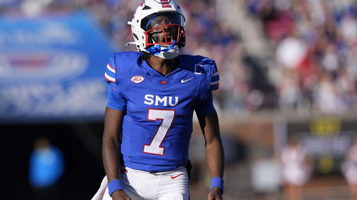 SMU quarterback Kevin Jennings (7) reacts to showing a touchdown pass to teammate wide receiver Derrick McFall (20) during the first half of an NCAA college football game against California, Saturday, Nov. 30, 2024, in Dallas.