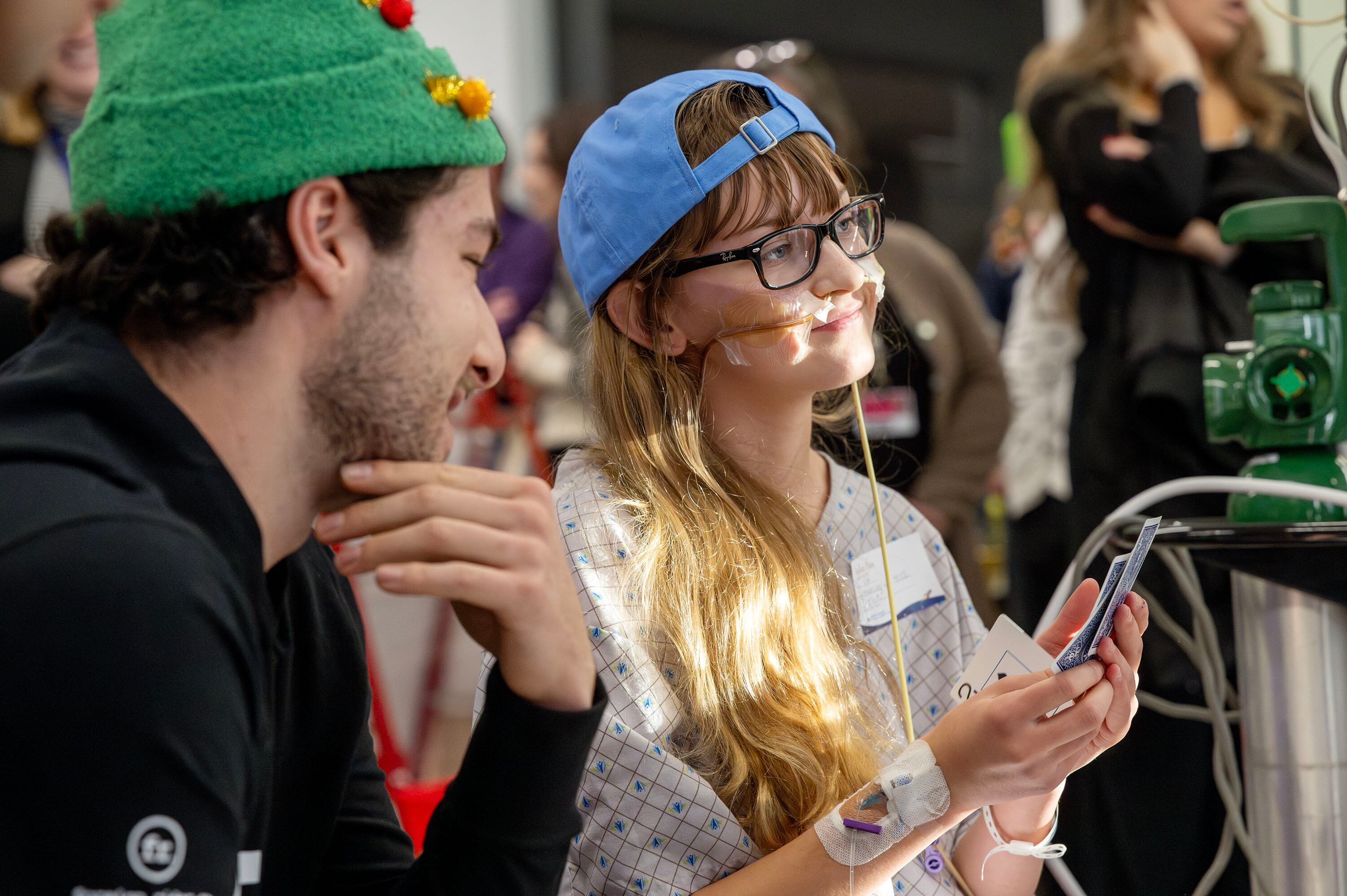 Mila Shaw and Utah HC defenseman Sean Durzi look over at Robert Bortuzzo as they play a game of Go Fish as members of the Utah Hockey Club visit the kids at Primary Children’s Hospital in Lehi on Wednesday.