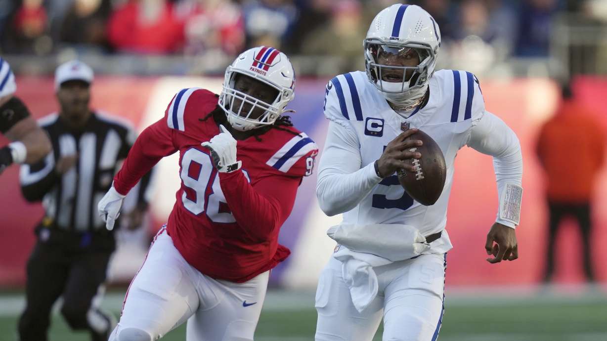 Indianapolis Colts quarterback Anthony Richardson (5) carries the ball against New England Patriots defensive tackle Jeremiah Pharms Jr. (98) during the second half of an NFL football game, Sunday, Dec. 1, 2024, in Foxborough, Mass.