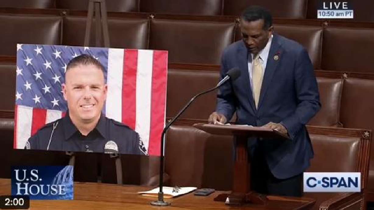Rep. Burgess Owens speaks at the U.S. Capitol in Washington next to a photo of Santaquin Police Sgt. Bill Hooser on Wednesday.