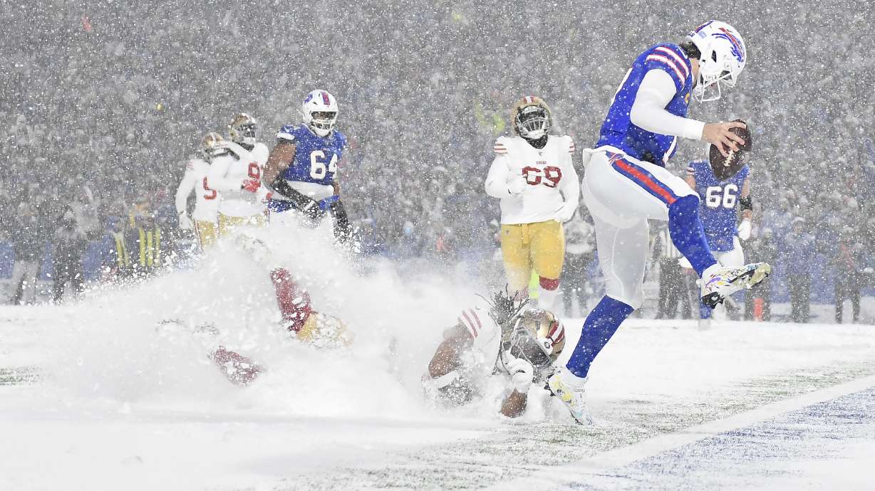Buffalo Bills quarterback Josh Allen, right, scores past San Francisco 49ers linebacker Fred Warner, bottom, during the second half of an NFL football game in Orchard Park, N.Y., Sunday, Dec. 1, 2024.