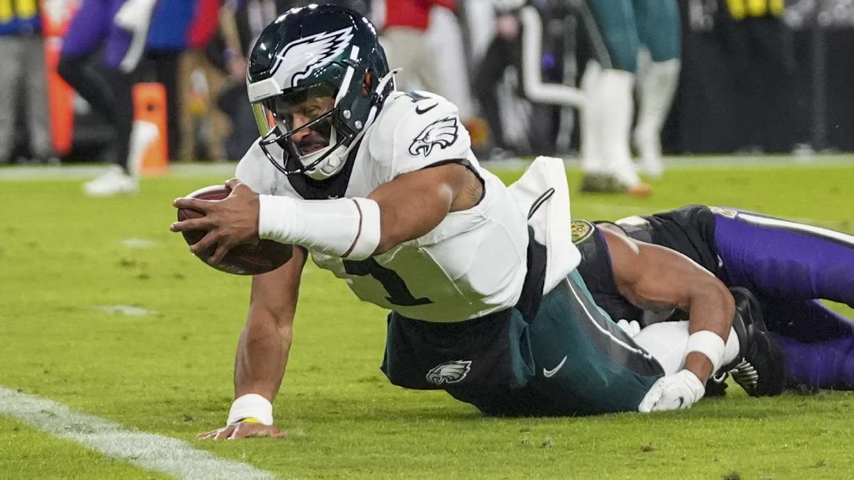 Philadelphia Eagles quarterback Jalen Hurts tries to stretch to score on a keeper against the Baltimore Ravens during the first half of an NFL football game, Sunday, Dec. 1, 2024, in Baltimore.