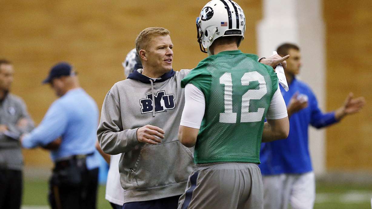 Quarterbacks Coach Jason Beck works with McCoy Hill during Brigham Young University football practice in Provo, Monday, March 2, 2015.
