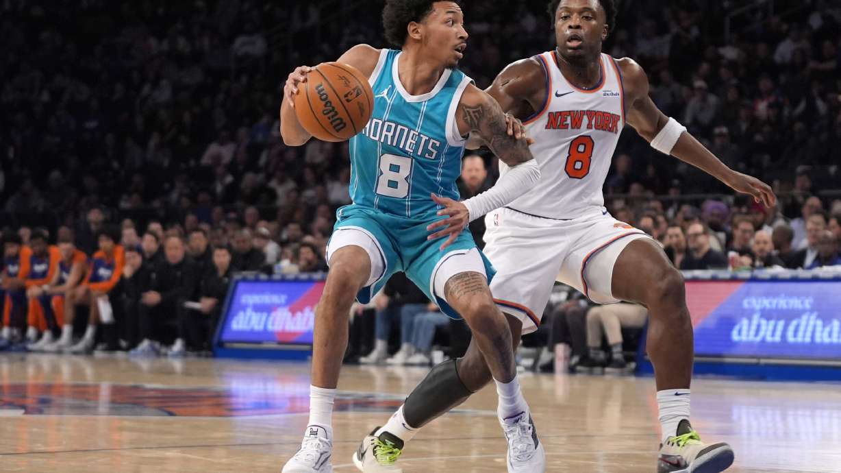 Charlotte Hornets' Nick Smith Jr., left, dribbles the ball against New York Knicks' OG Anunoby, right, during the first half of an NBA basketball game Thursday, Dec. 5, 2024, in New York.