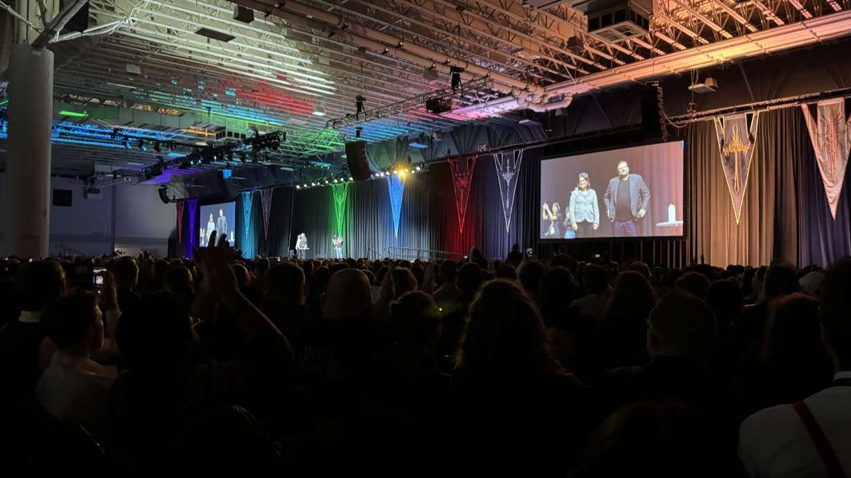 Brandon Sanderson and his wife, Emily Sanderson, speak at the release event for his book "Wind and Truth" at the Salt Palace Convention Center in Salt Lake City on Thursday. The event kicked off the author's DragonSteel Nexus 2024 convention.
