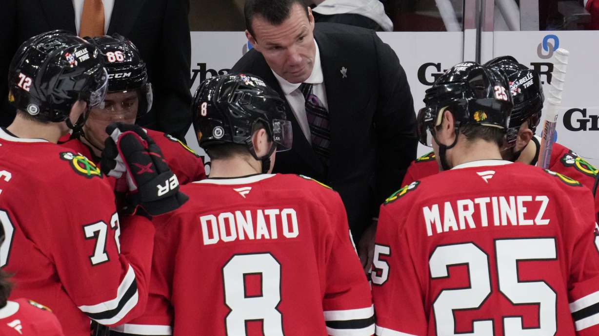 Chicago Blackhawks head coach Luke Richardson, center top, talks to his players during the third period of an NHL hockey game against the Columbus Blue Jackets in Chicago, Sunday, Dec.1, 2024.