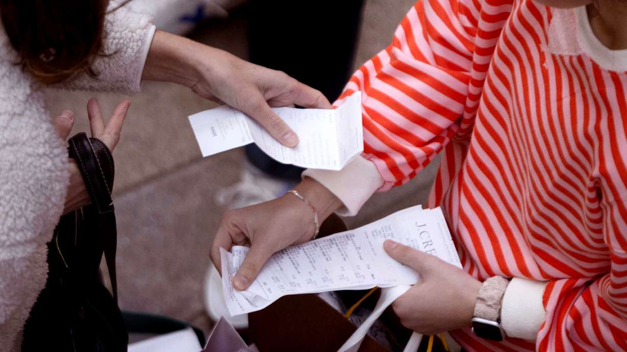 Consumers organize their receipts while shopping at the City Creek Center in Salt Lake City on Friday, Nov. 29.