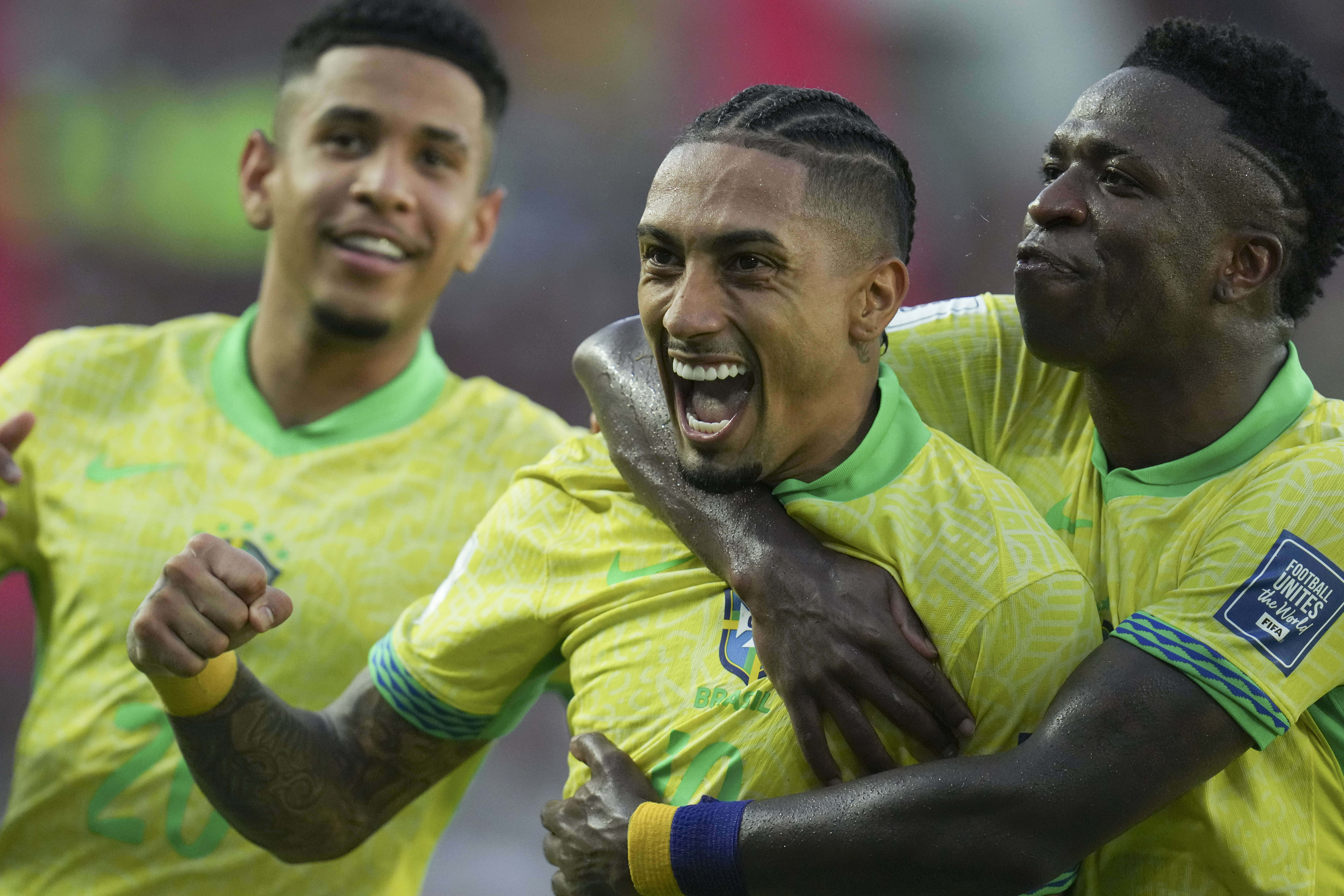 Brazil's Raphinha, center, celebrates with teammate Vinicius Junior, right, after scoring his side's opening goal against Venezuela during a FIFA World Cup 2026 qualifying soccer match at Monumental stadium in Maturin, Venezuela, Thursday, Nov. 14, 2024.