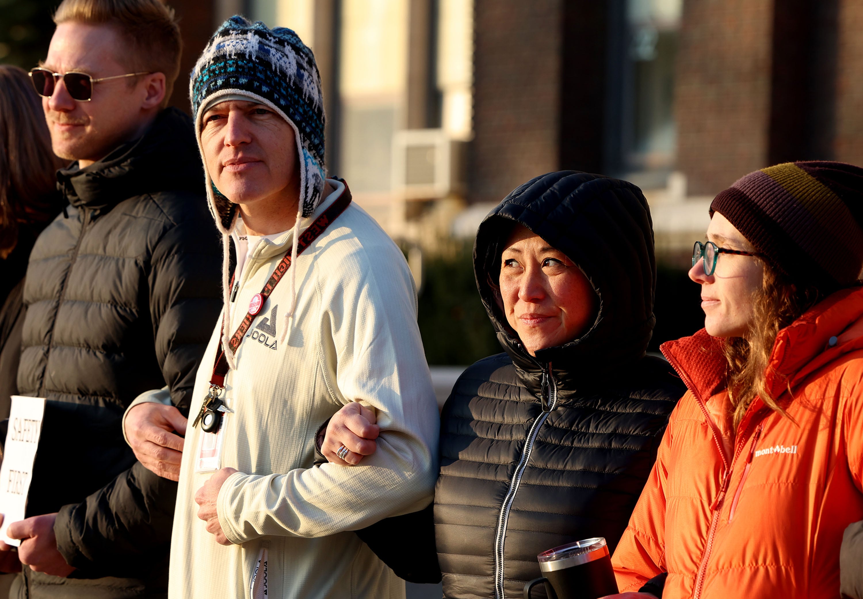 Teachers and staff link arms in solidarity to protest the lack of school safety at West High School in Salt Lake City on Friday, Dec. 6, 2024.