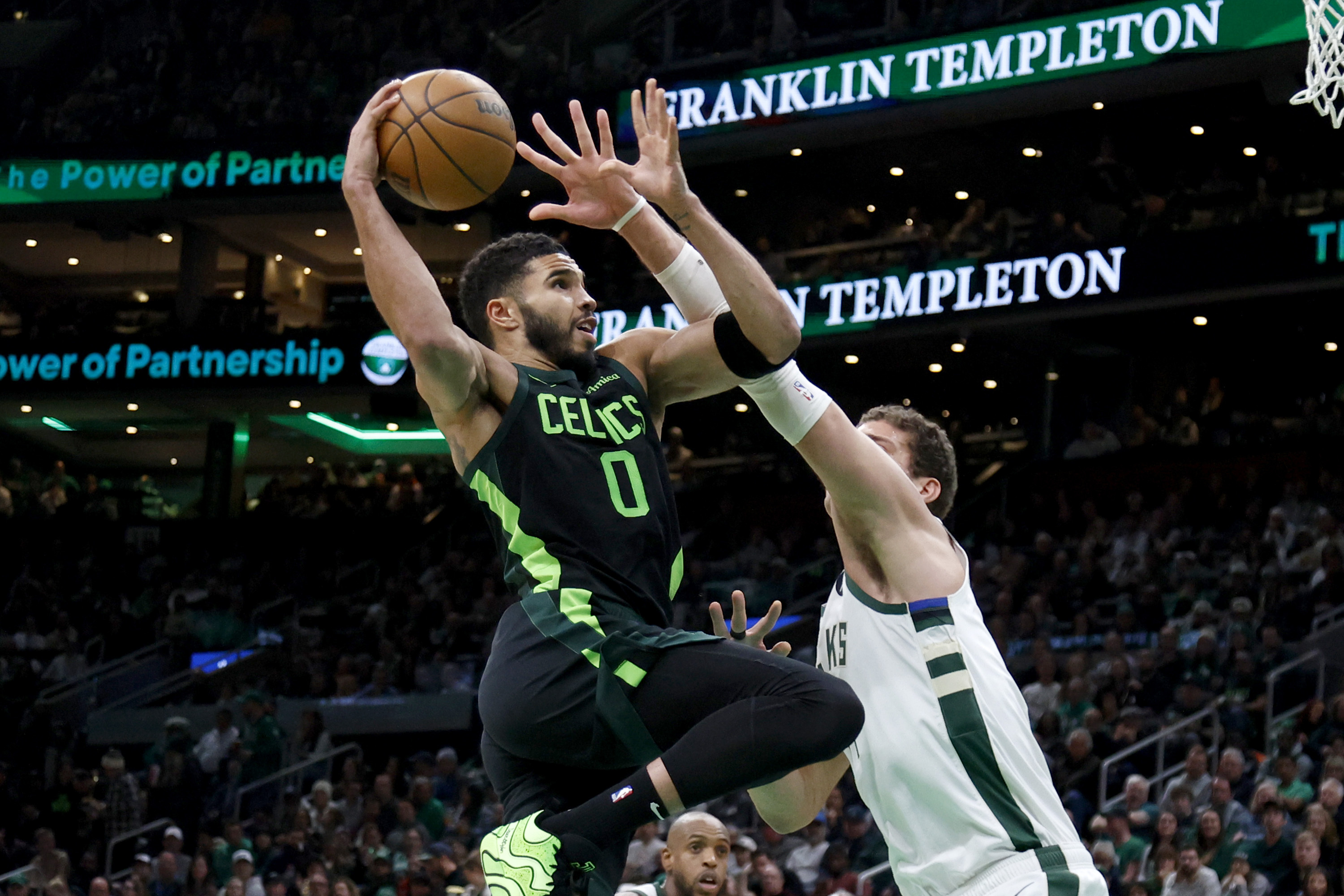 Boston Celtics forward Jayson Tatum (0) drives to the basket against Milwaukee Bucks center Brook Lopez (11) during the first half of an NBA basketball game, Friday, Dec. 6, 2024, in Boston.