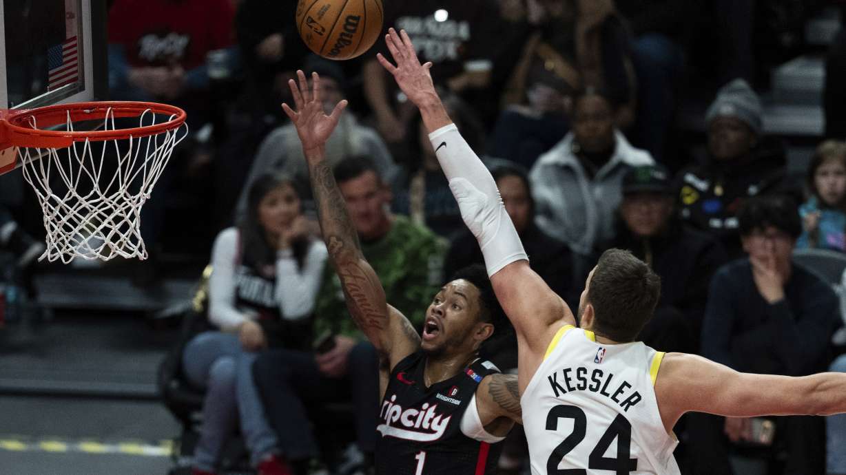 Utah Jazz center Walker Kessler (24) tries to block the shot of Portland Trail Blazers guard Anfernee Simons (1) during the first half of an NBA basketball game Friday, Dec. 6, 2024, in Portland, Ore.
