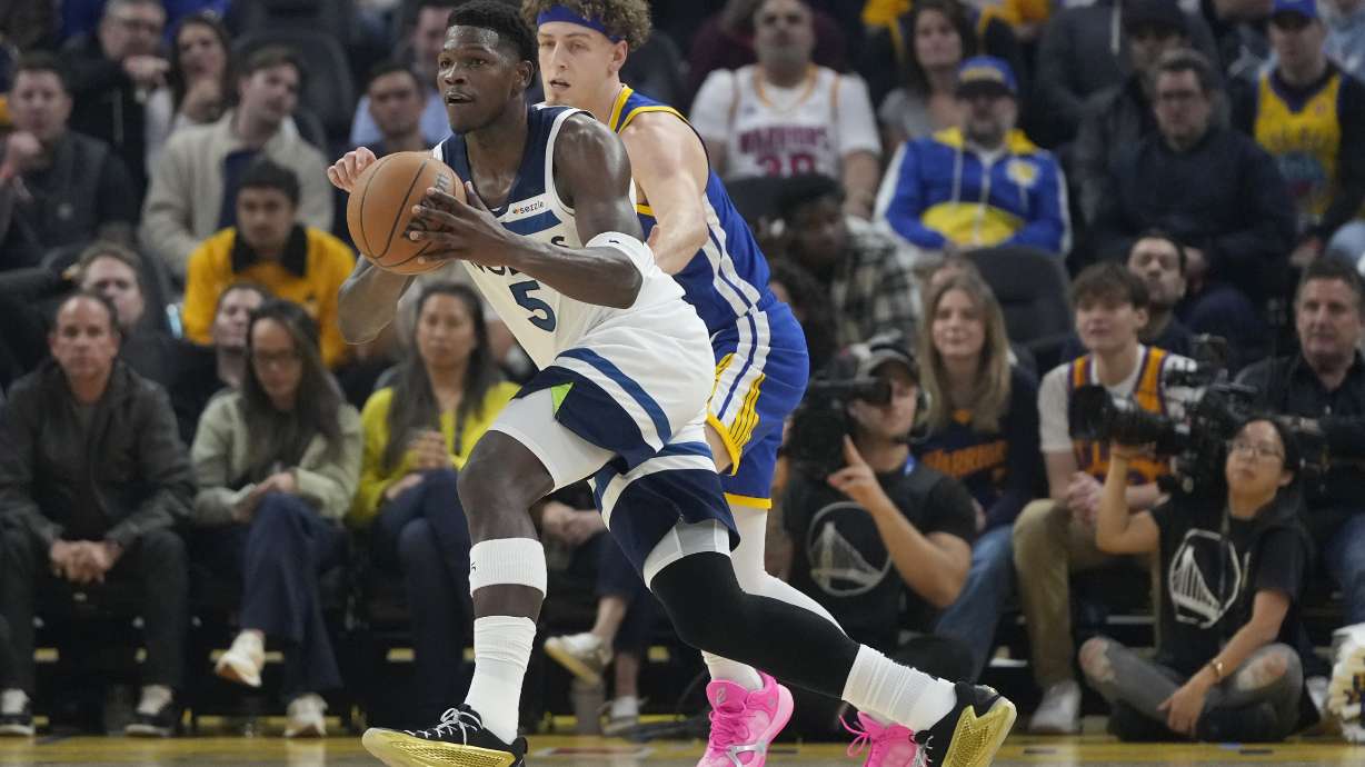 Minnesota Timberwolves guard Anthony Edwards (5) passes the ball in front of Golden State Warriors guard Brandin Podziemski during the first half of an NBA basketball game in San Francisco, Friday, Dec. 6, 2024.