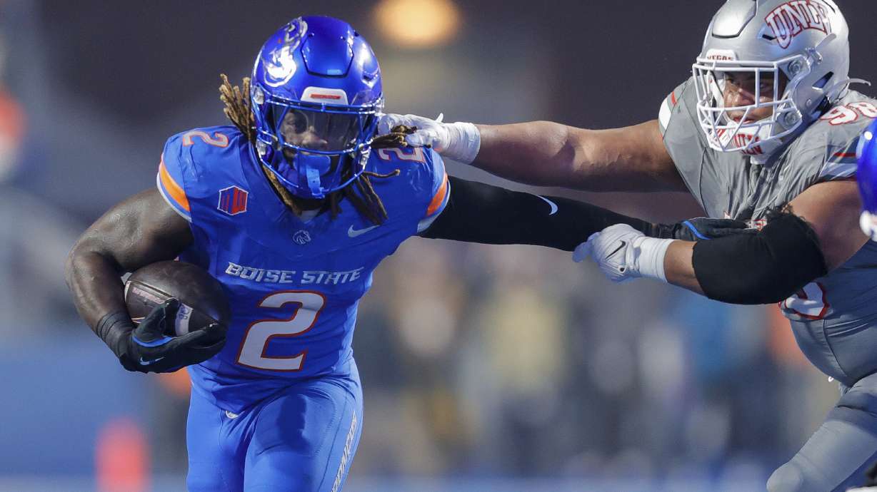 Boise State running back Ashton Jeanty (2) pushes away from the arms of UNLV defensive lineman Tatuo Martinson (98) on a run in the first half of the Mountain West Championship NCAA college football game Friday, Dec. 6, 2024, in Boise, Idaho.