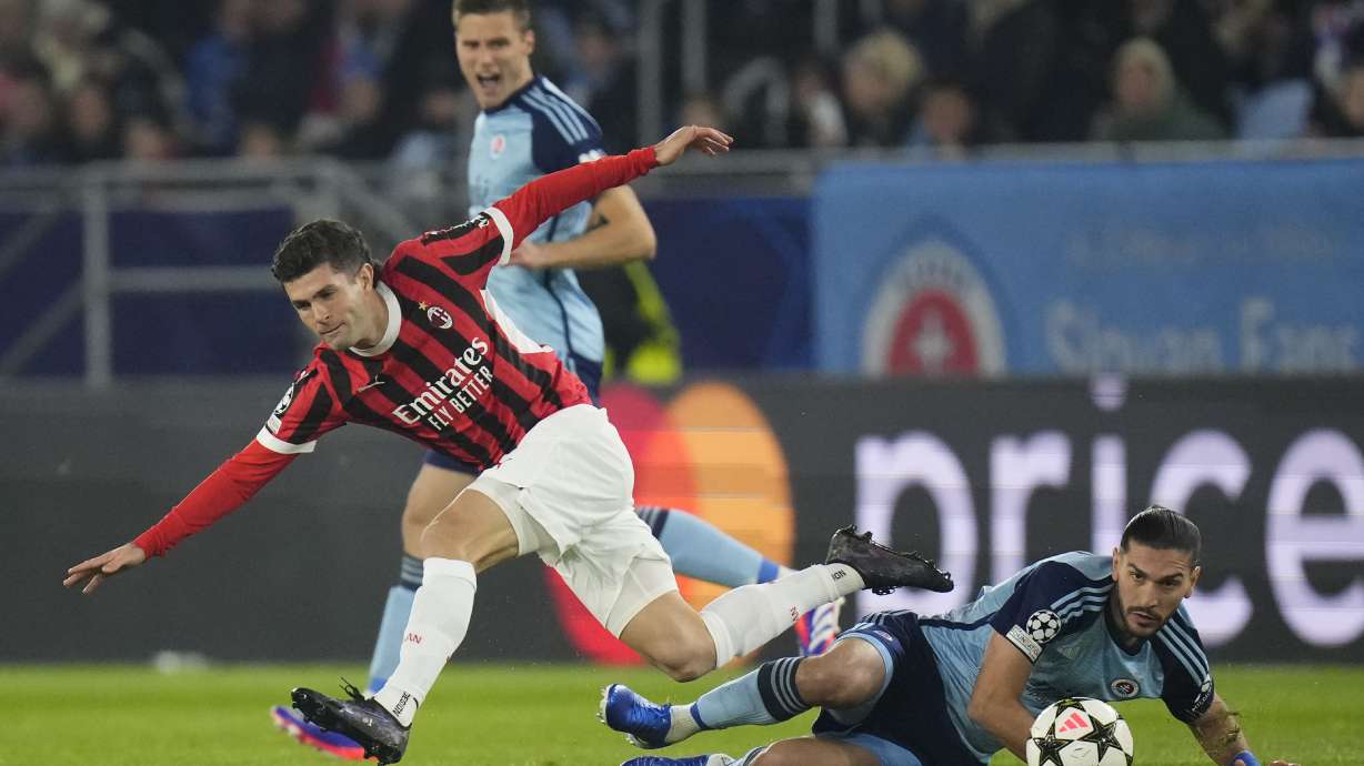 AC Milan's Christian Pulisic, left, Slovan's Kyriakos Savvidis fight for the ball during the Champions League opening phase soccer match between Slovan Bratislava and AC Milan in Bratislava, Slovakia, on Tuesday, Nov. 26, 2024.