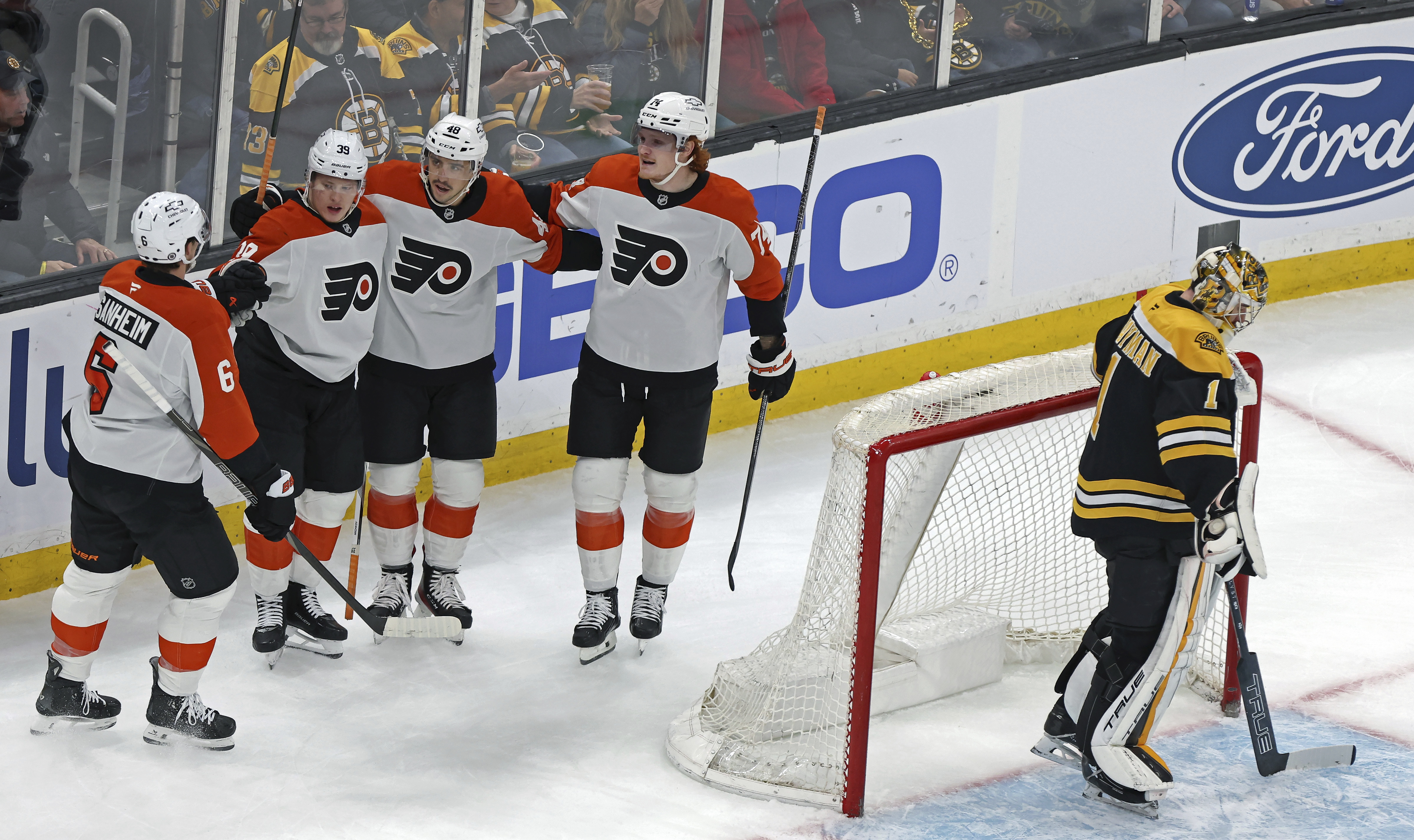 Philadelphia Flyers players, from left, Travis Sanheim, Matvei Michkov, Morgan Frost and Owen Tippett celebrate Michkov's second goal of the game past Boston Bruins goalie Jeremy Swayman during the first period of an NHL hockey game, Saturday, Dec. 7, 2024, in Boston.