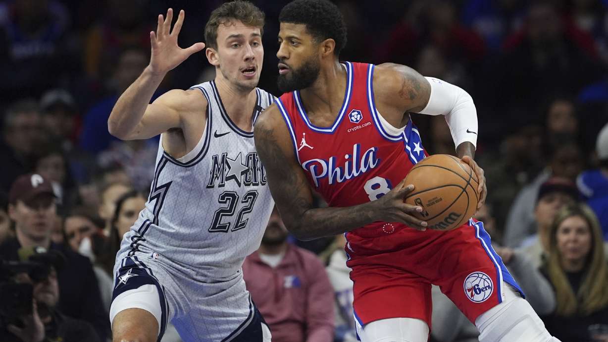 Philadelphia 76ers' Paul George, right, tries to get past Orlando Magic's Franz Wagner during the first half of an NBA basketball game, Friday, Dec. 6, 2024, in Philadelphia.
