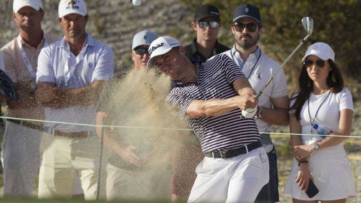 Justin Thomas, front, of the United States, watches his hit from the sand on the 16th hole during the third round of the Hero World Challenge PGA Tour at the Albany Golf Club in New Providence, Bahamas, Saturday, Dec. 7, 2024.