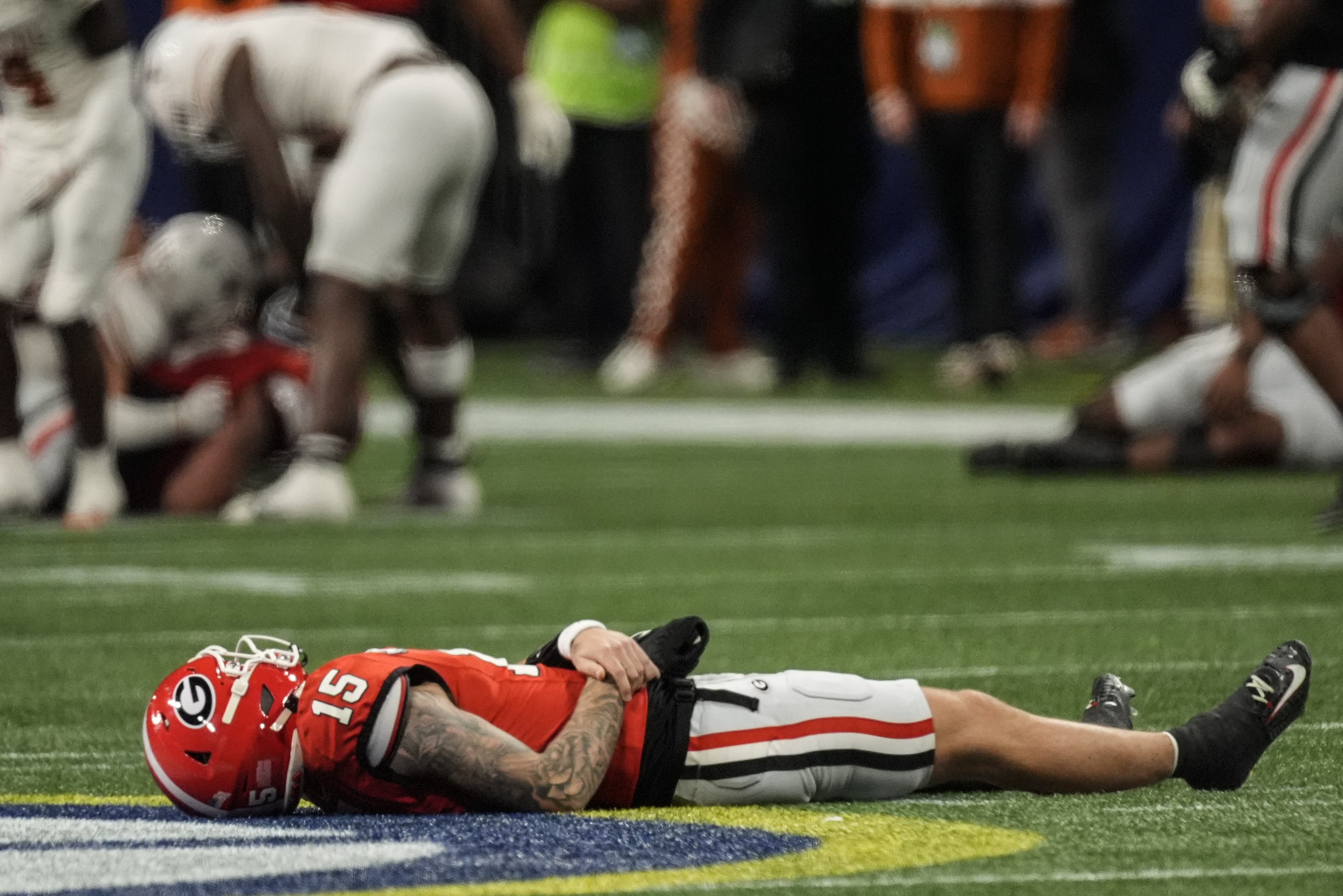 Georgia quarterback Carson Beck (15) lies on the turf injured against Texas during the first half of the Southeastern Conference championship NCAA college football game, Saturday, Dec. 7, 2024, in Atlanta.