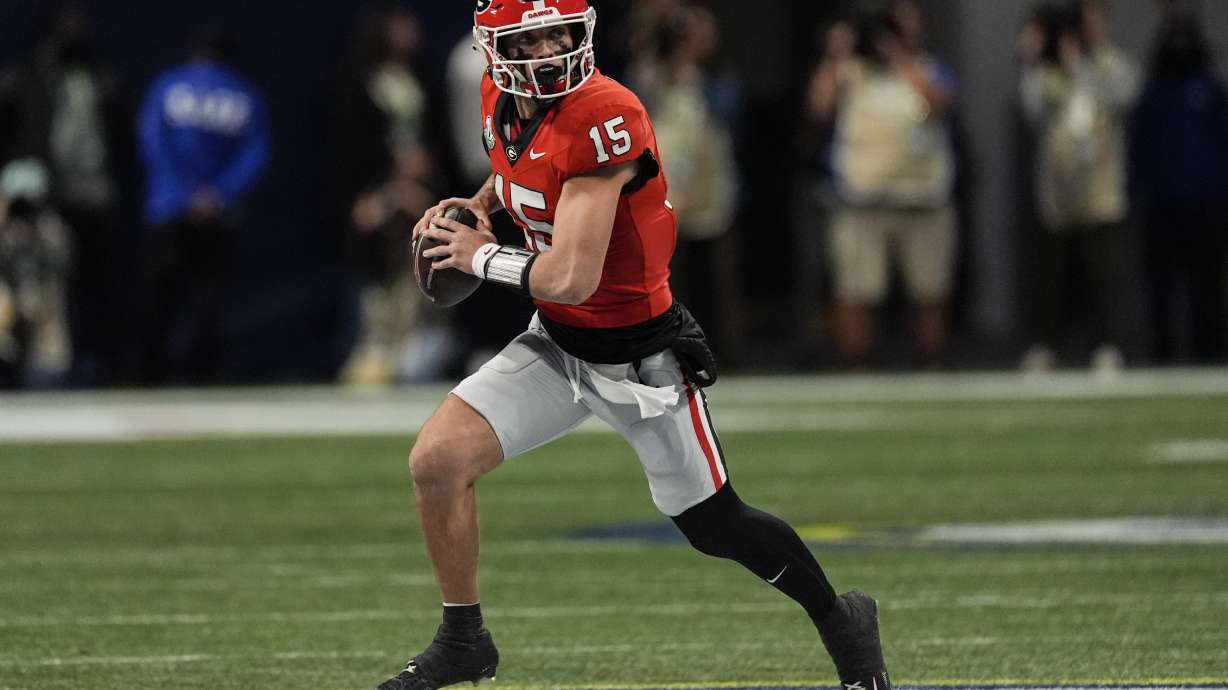 Georgia quarterback Carson Beck (15) runs out of the pocket against Texas during the first half of the Southeastern Conference championship NCAA college football game, Saturday, Dec. 7, 2024, in Atlanta.