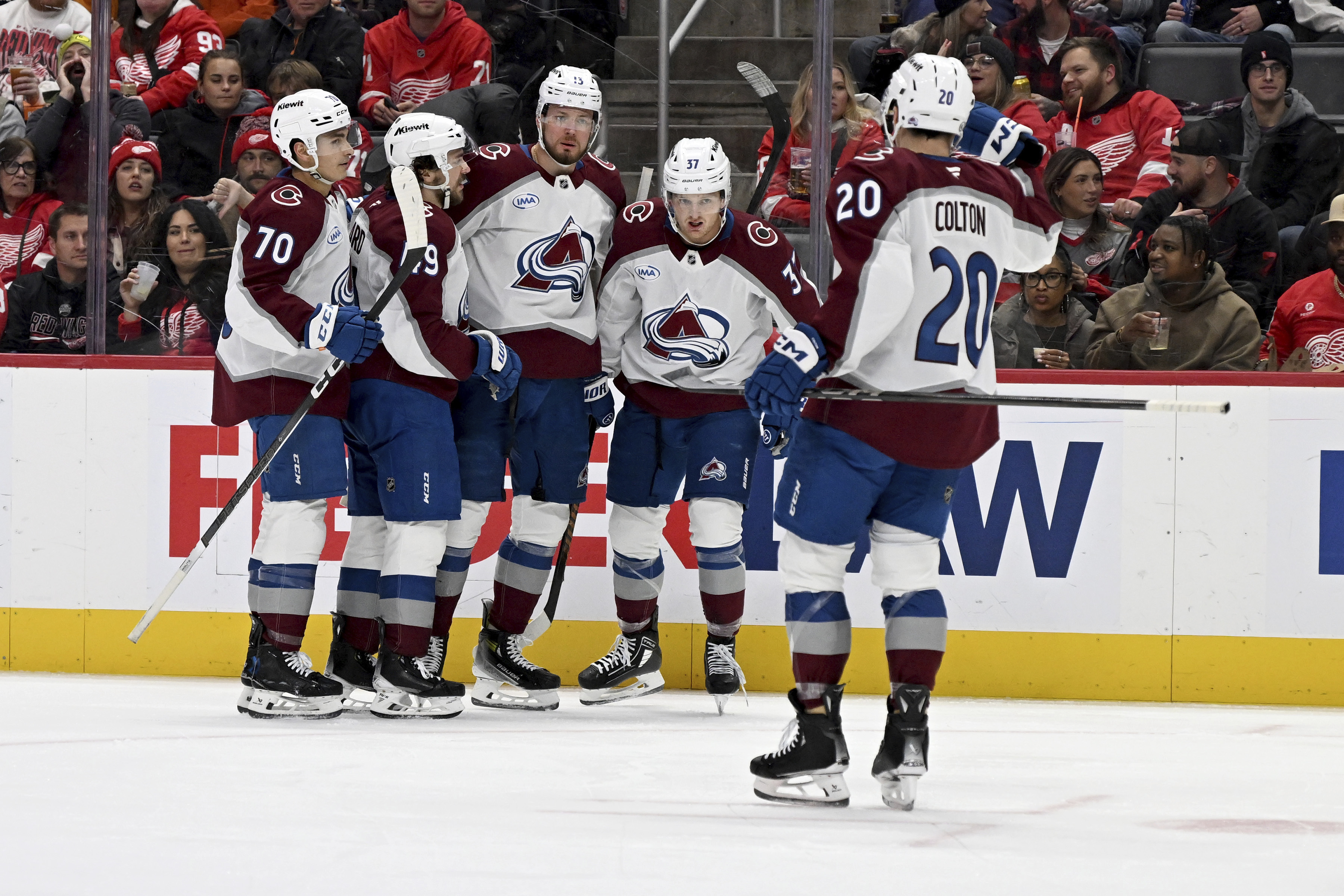 From left to right, Colorado Avalanche defenseman Sam Malinski (70), defenseman Samuel Girard (49), right wing Valeri Nichushkin (13) and center Casey Mittelstadt (37) wait to celebrate with center Ross Colton (20) after Colton scored against the Detroit Red Wings in the first period of an NHL hockey game Saturday, Dec. 7, 2024, in Detroit.