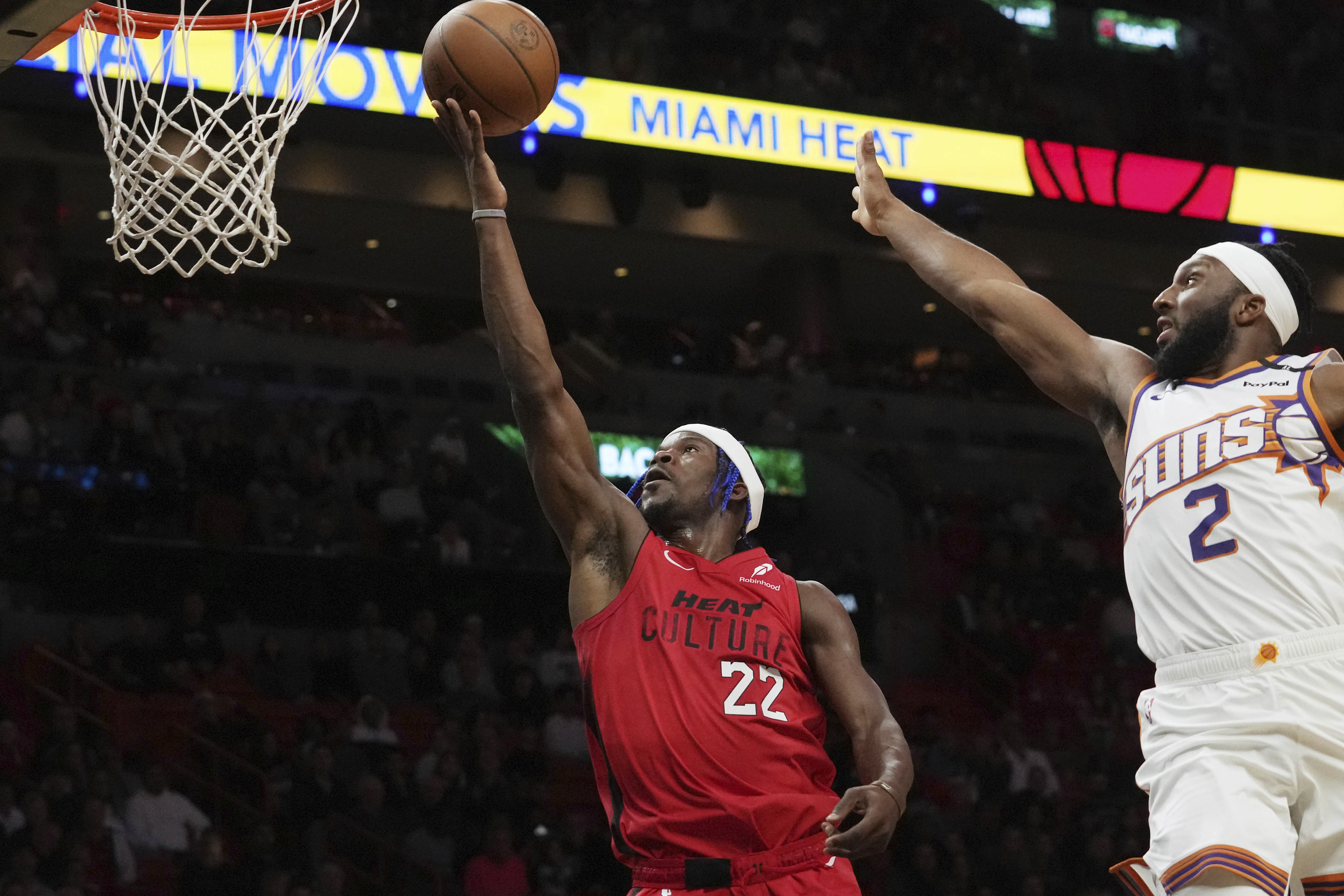 Miami Heat forward Jimmy Butler (22) drives to the basket as Phoenix Suns forward Josh Okogie (2) defends during the first half of an NBA basketball game, Saturday, Dec. 7, 2024, in Miami.