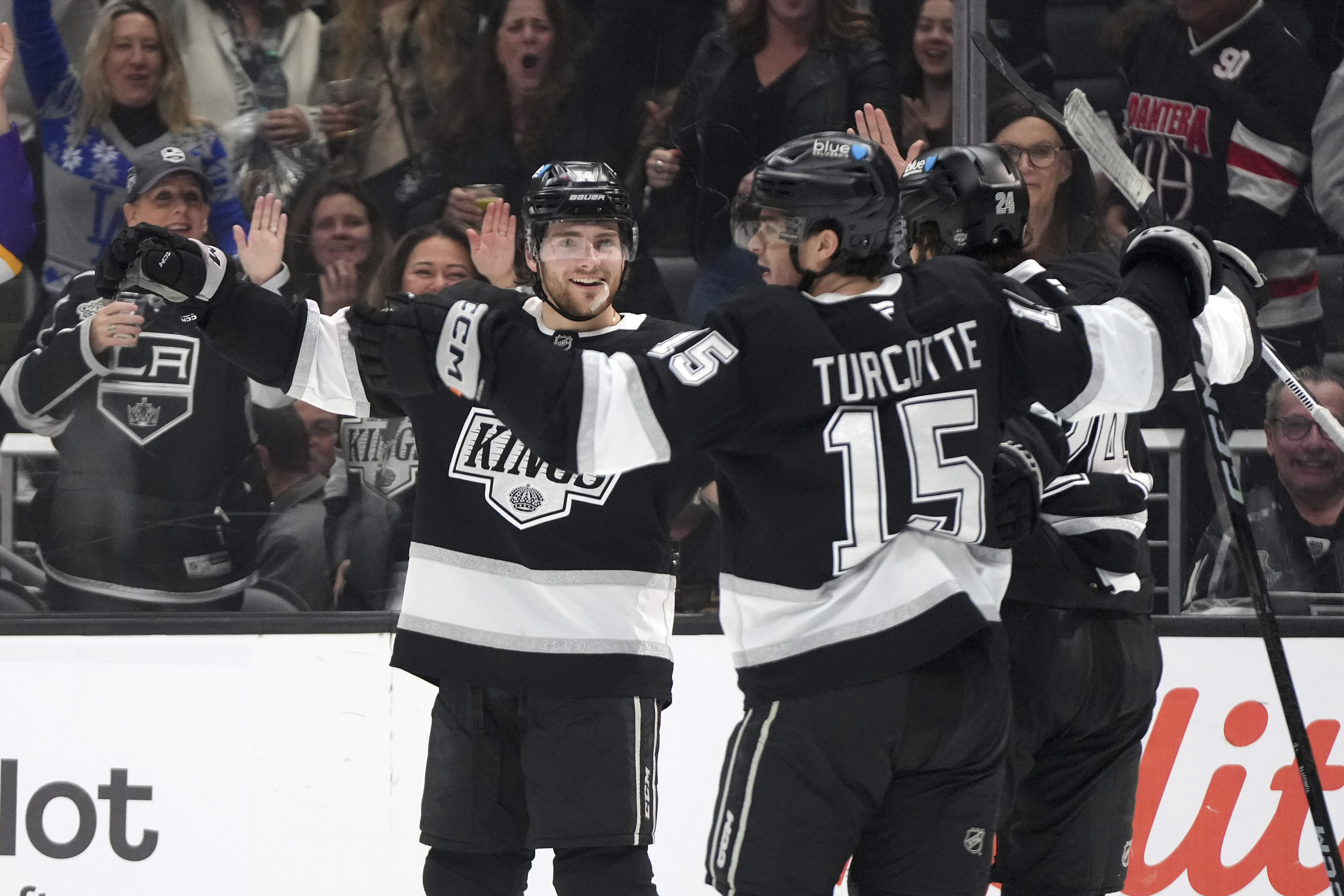 Los Angeles Kings right wing Alex Laferriere, left, celebrates his goal with center Alex Turcotte, center, and center Phillip Danault during the second period of an NHL hockey game against the Minnesota Wild, Saturday, Dec. 7, 2024, in Los Angeles.