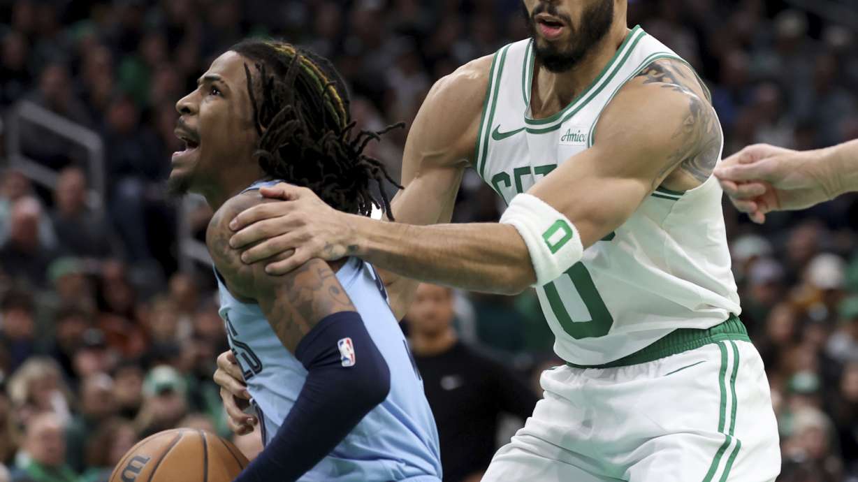Boston Celtics forward Jayson Tatum, right, fouls Memphis Grizzlies guard Ja Morant, left, during the first half of an NBA basketball game, Saturday, Dec. 7, 2024, in Boston.