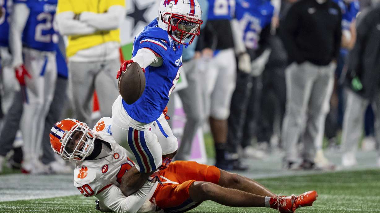 Clemson cornerback Avieon Terrell (20) tackles SMU wide receiver Jordan Hudson, top, in the first half of the Atlantic Coast Conference championship NCAA college football game Saturday, Dec. 7, 2024, in Charlotte, N.C.