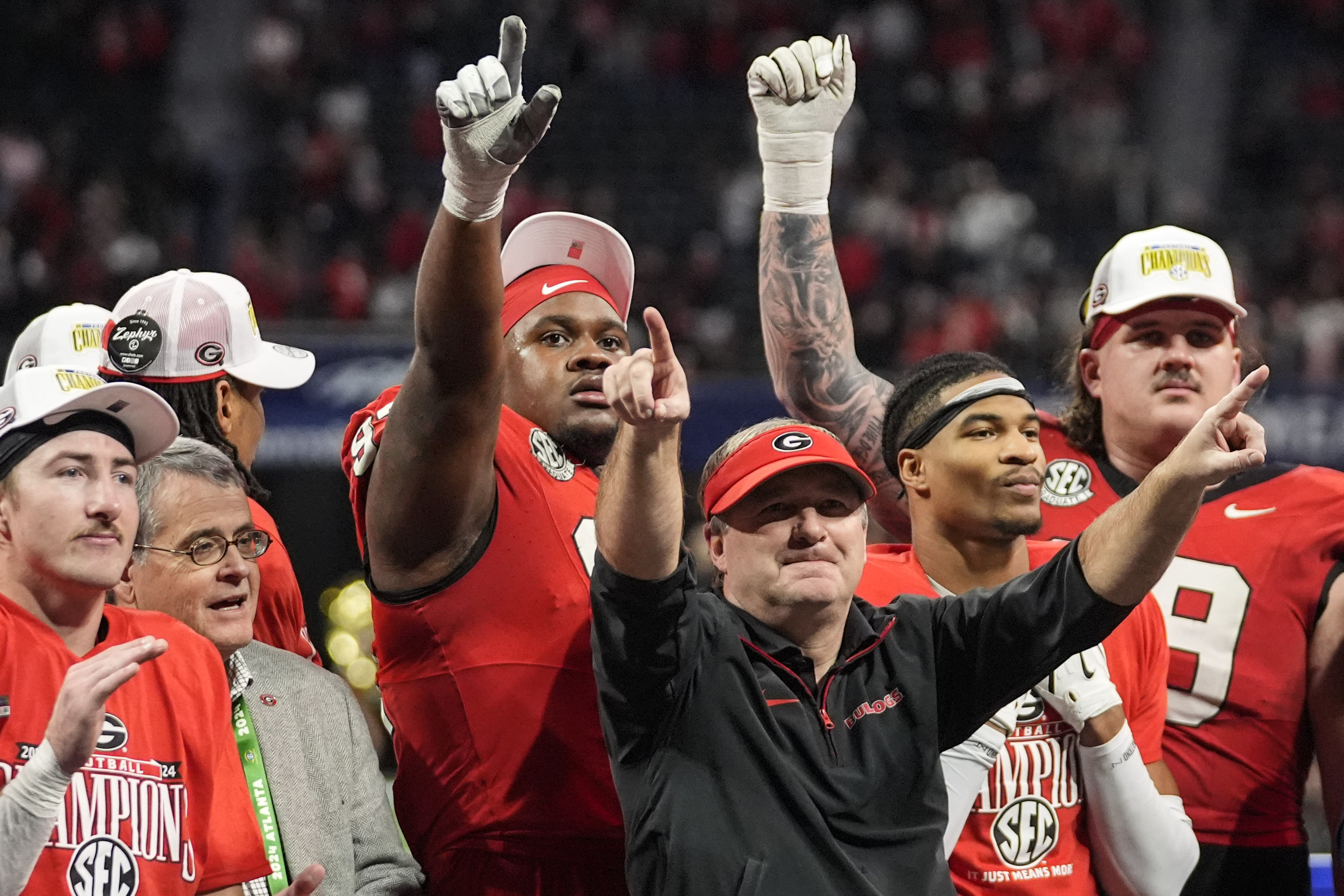 Georgia head coach Kirby Smart and players celebrate a win over Texas after the Southeastern Conference championship NCAA college football game, Saturday, Dec. 7, 2024, in Atlanta.