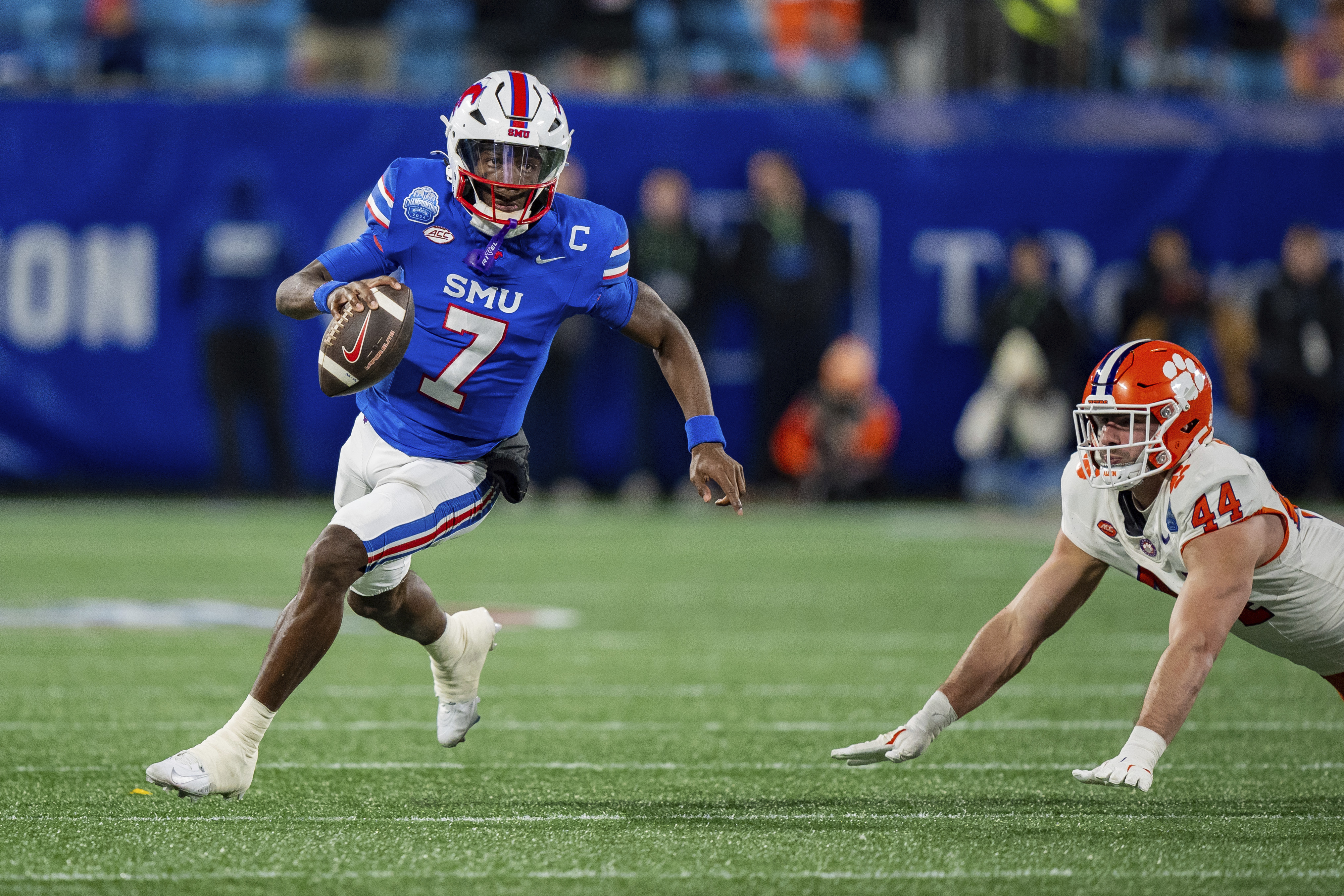 SMU quarterback Kevin Jennings (7) runs past Clemson defensive end Cade Denhoff (44) in the first half of the Atlantic Coast Conference championship NCAA college football game Saturday, Dec. 7, 2024, in Charlotte, N.C.