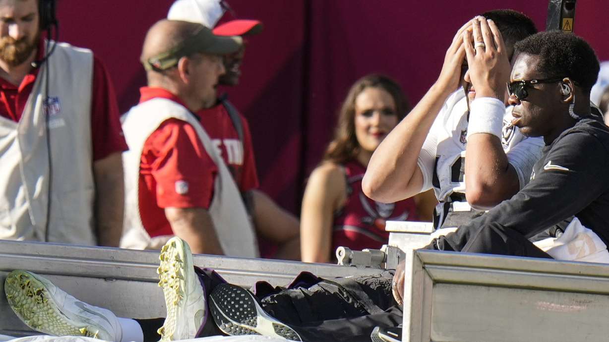 Las Vegas Raiders quarterback Aidan O'Connell (12) is taken off the field after an injury against the Tampa Bay Buccaneers during the second half of an NFL football game, Sunday, Dec. 8, 2024, in Tampa, Fla.