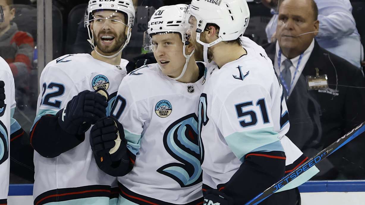 Seattle Kraken's Eeli Tolvanen (20) celebrates his goal with Oliver Bjorkstrand (22) and Shane Wright (51) against the New York Rangers during the second period of an NHL hockey game, Sunday, Dec. 8, 2024, in New York.