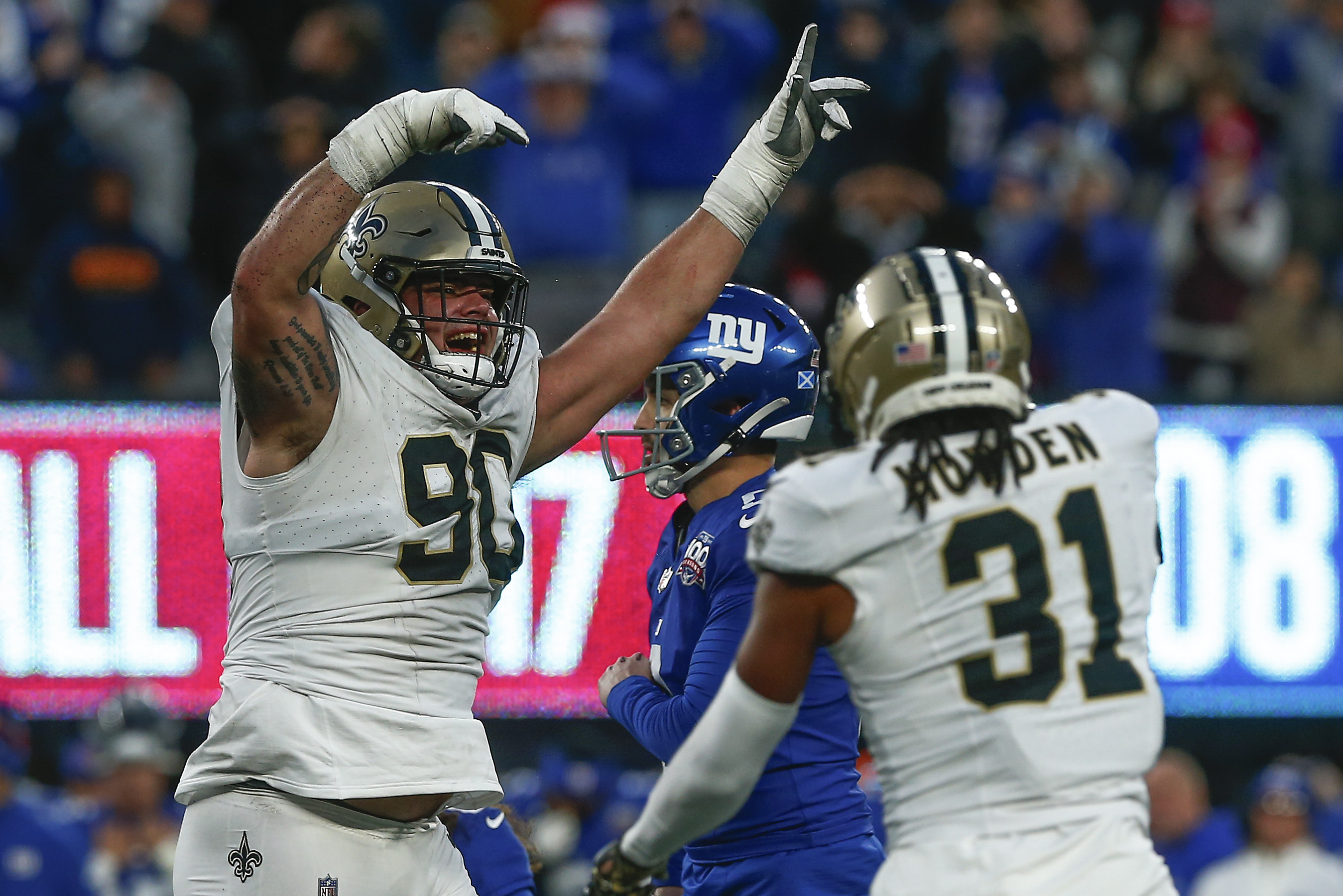 New Orleans Saints defensive tackle Bryan Bresee (90) and safety Jordan Howden (31) celebrate after the New York Giants missed a field goal late in the fourth quarter of an NFL football game, Sunday, Dec. 8, 2024, in East Rutherford, N.J.